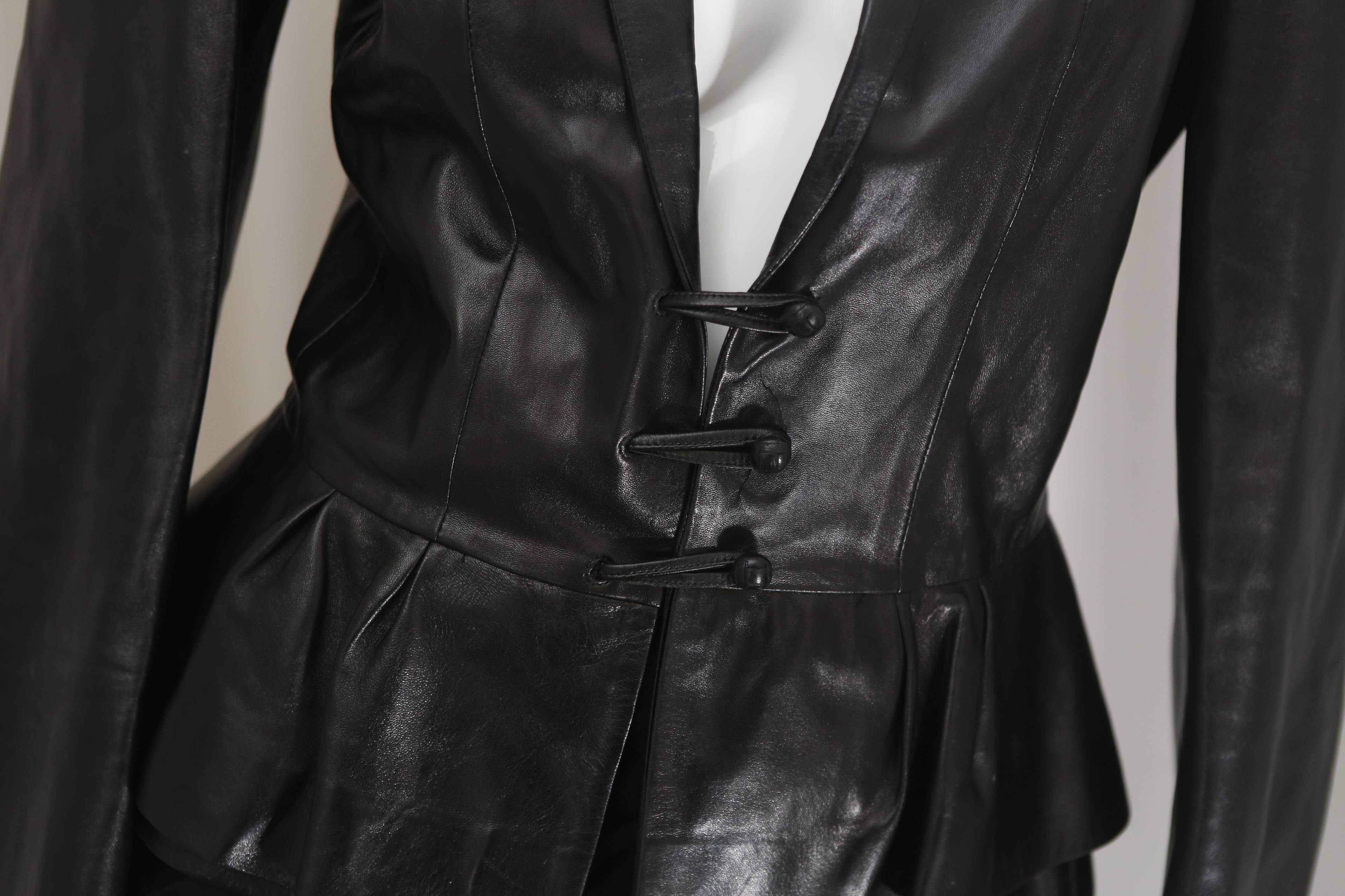 YSL black leather long sleeve peplum jacket with collar, wrist cuffs & three-button toggle closure. 

Sleeve-Length: 27