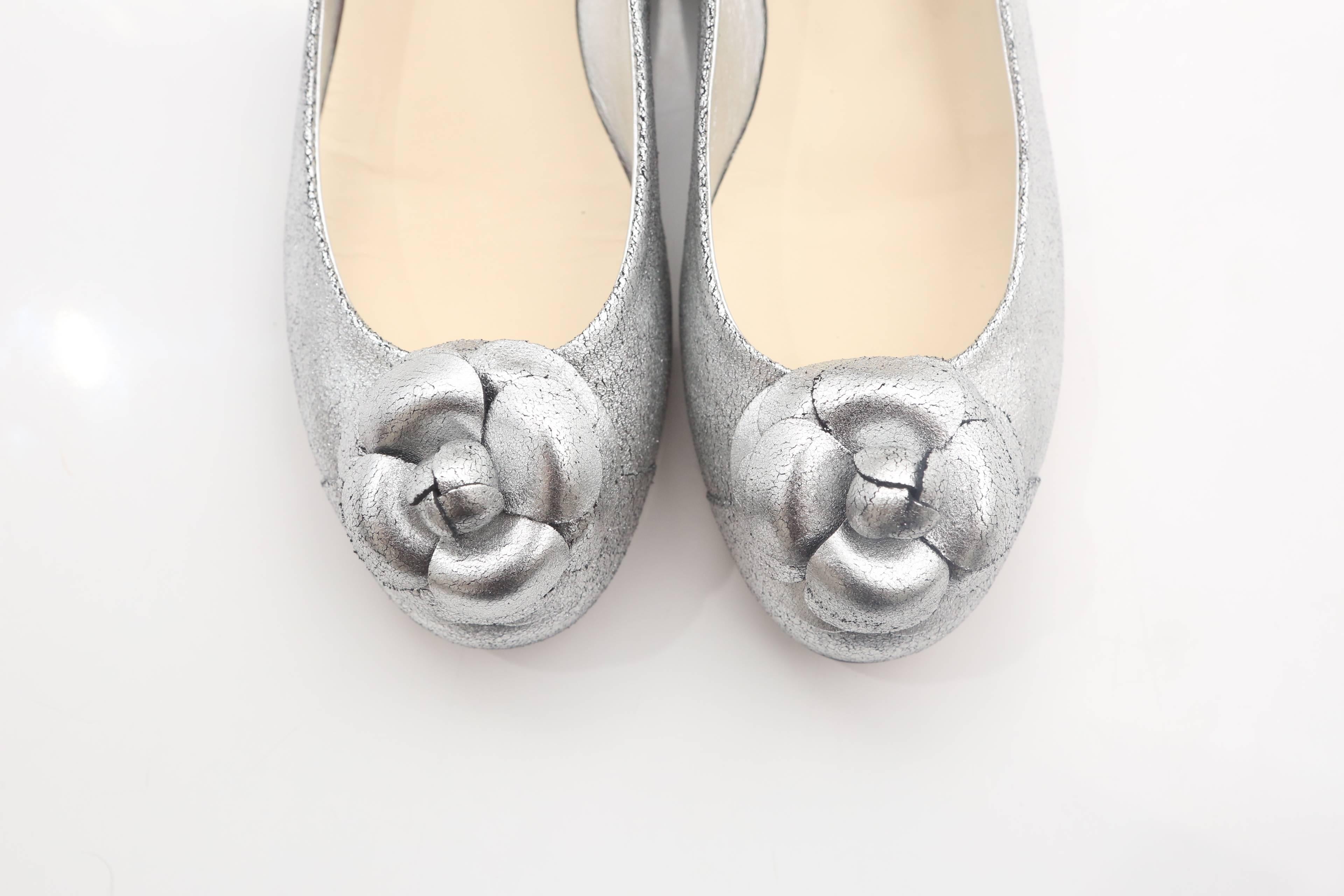 Chanel silver flats with rosette, round toe and small heel.

W/ Box