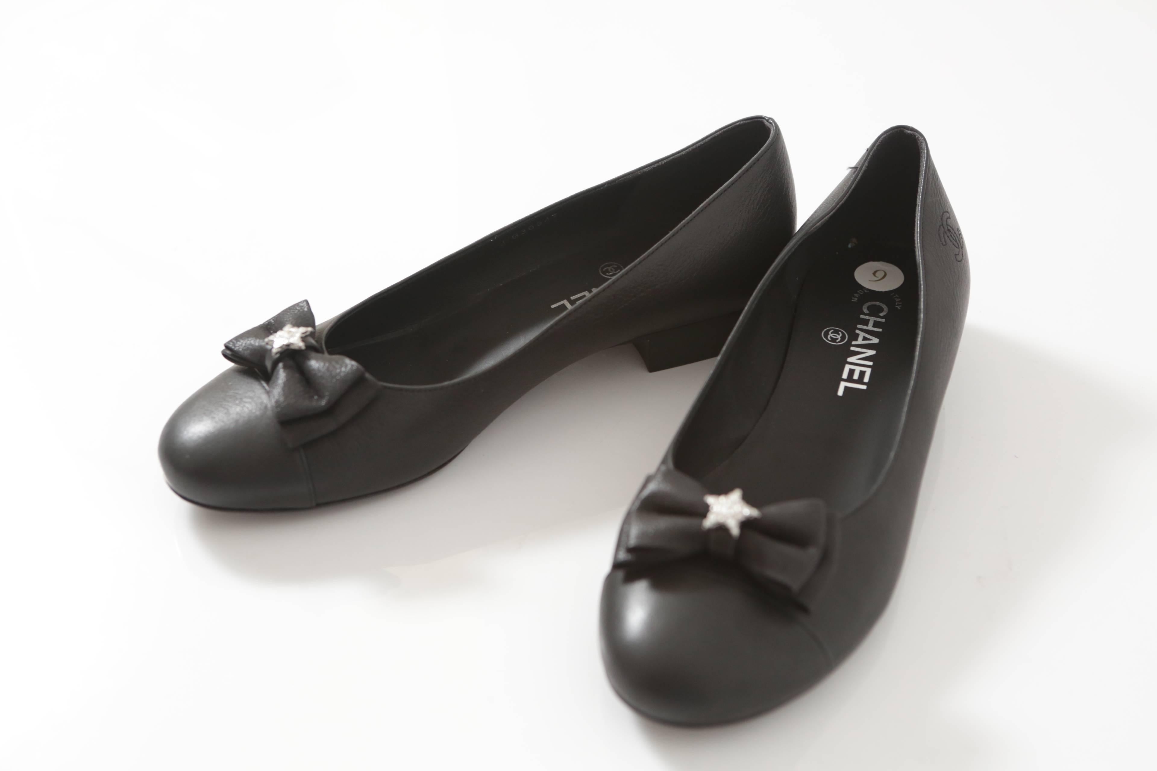 Chanel classic black leather flats with Grosgrain Bow & crystal star.  Comes with original box.