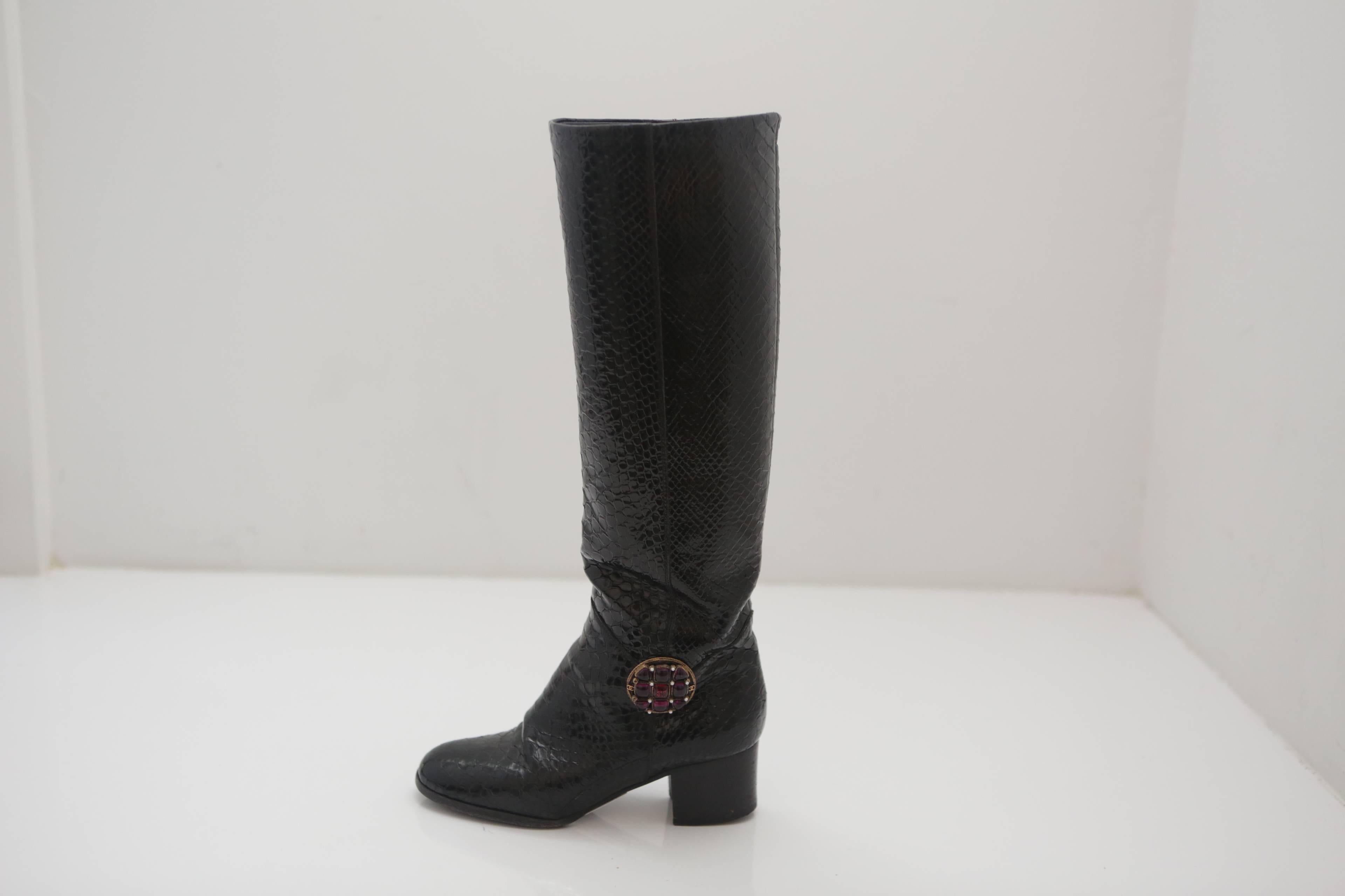 Chanel pair of black snakeskin boots with 15" zipper less shaft, 2" heel and ruby colored stone & pearl adornment. 