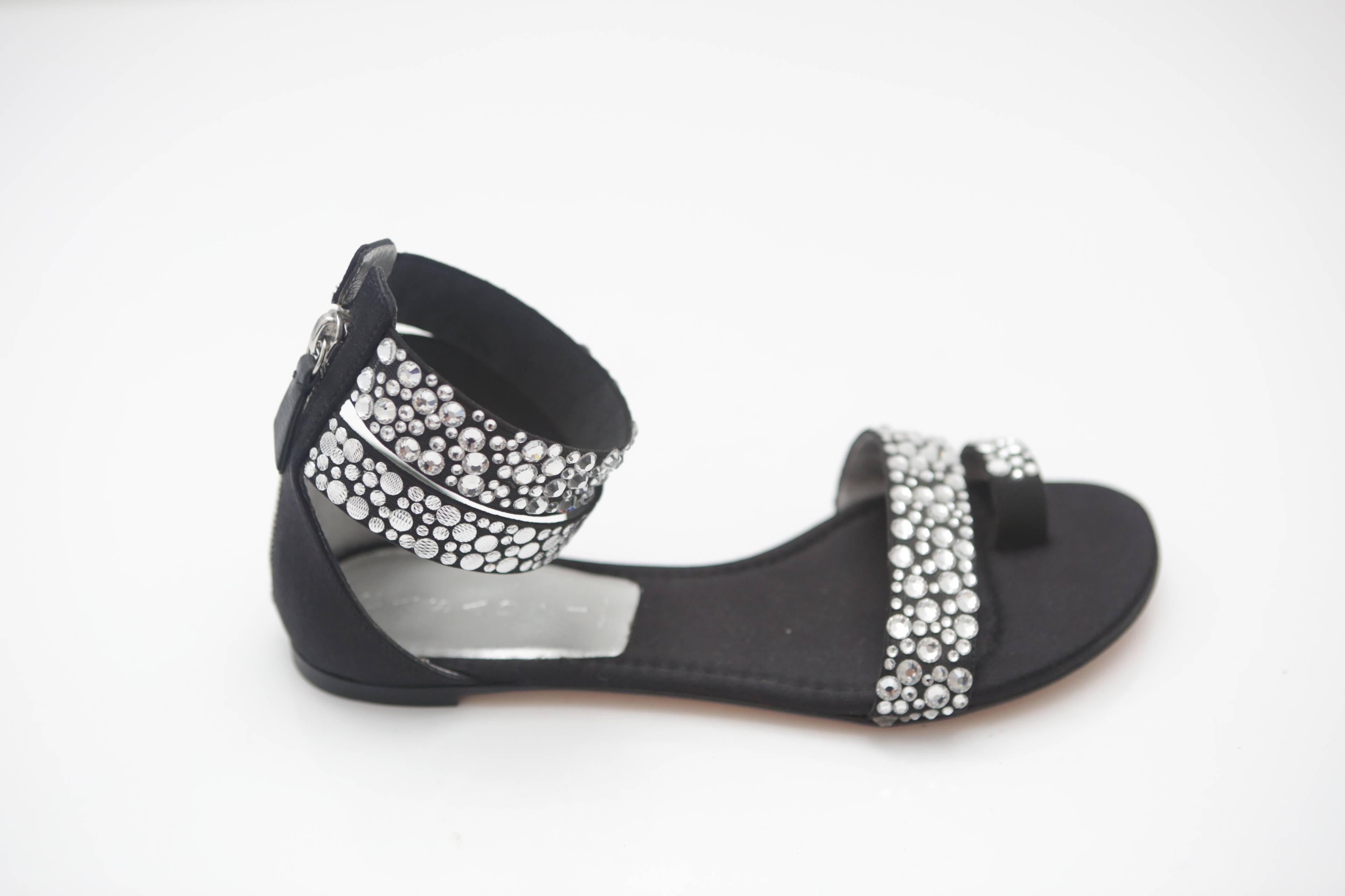 A pair of Casadei sandal flats with crystals in various sizes, satin interior and silver leather at back. Back zip and elasticized toe band. 