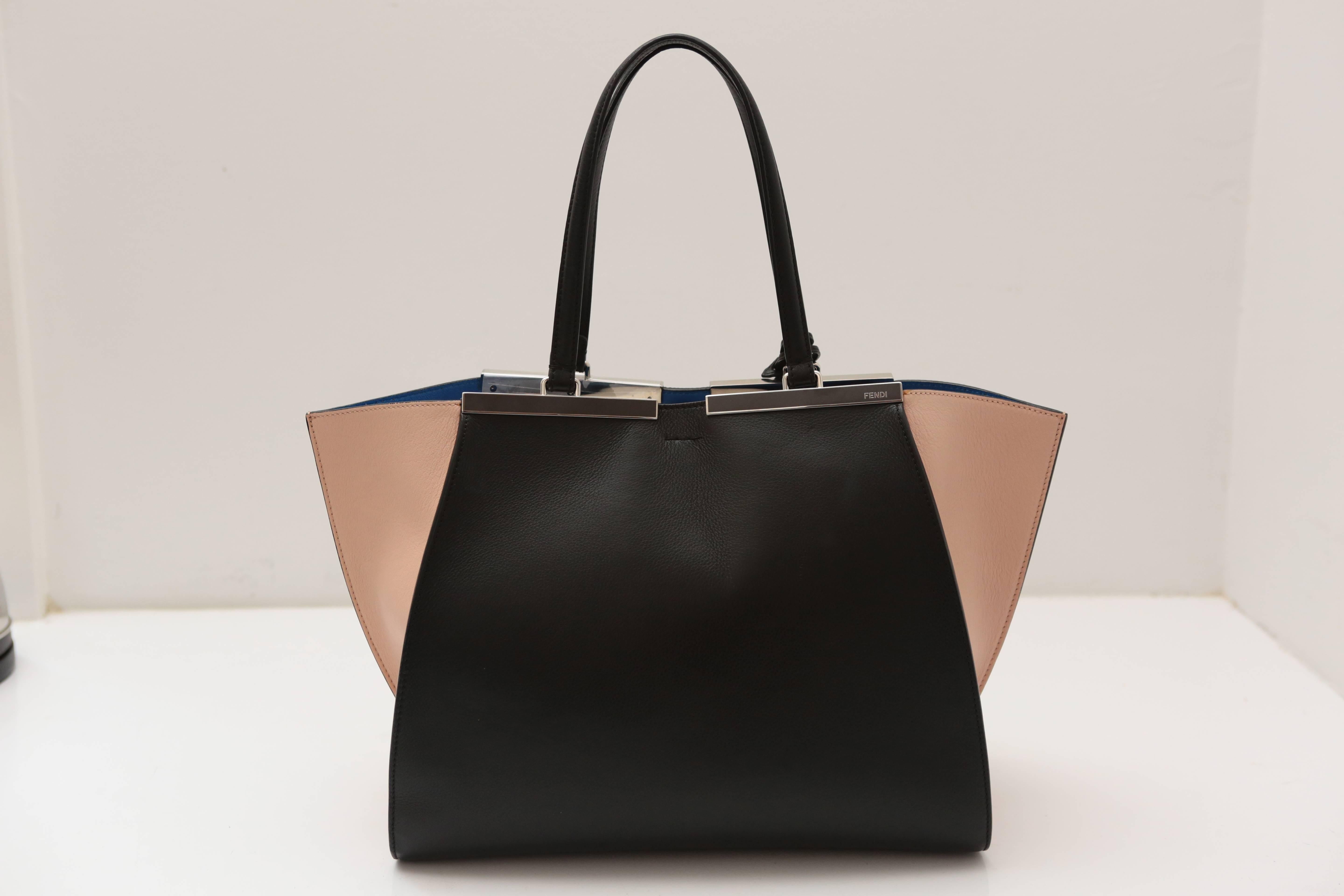Black and nude leather exterior with blue micro suede interior featuring a tab snap top closure and jut-out sides to create extra space.  Polished silver hardware completes this must-have classic from the House of Fendi. 