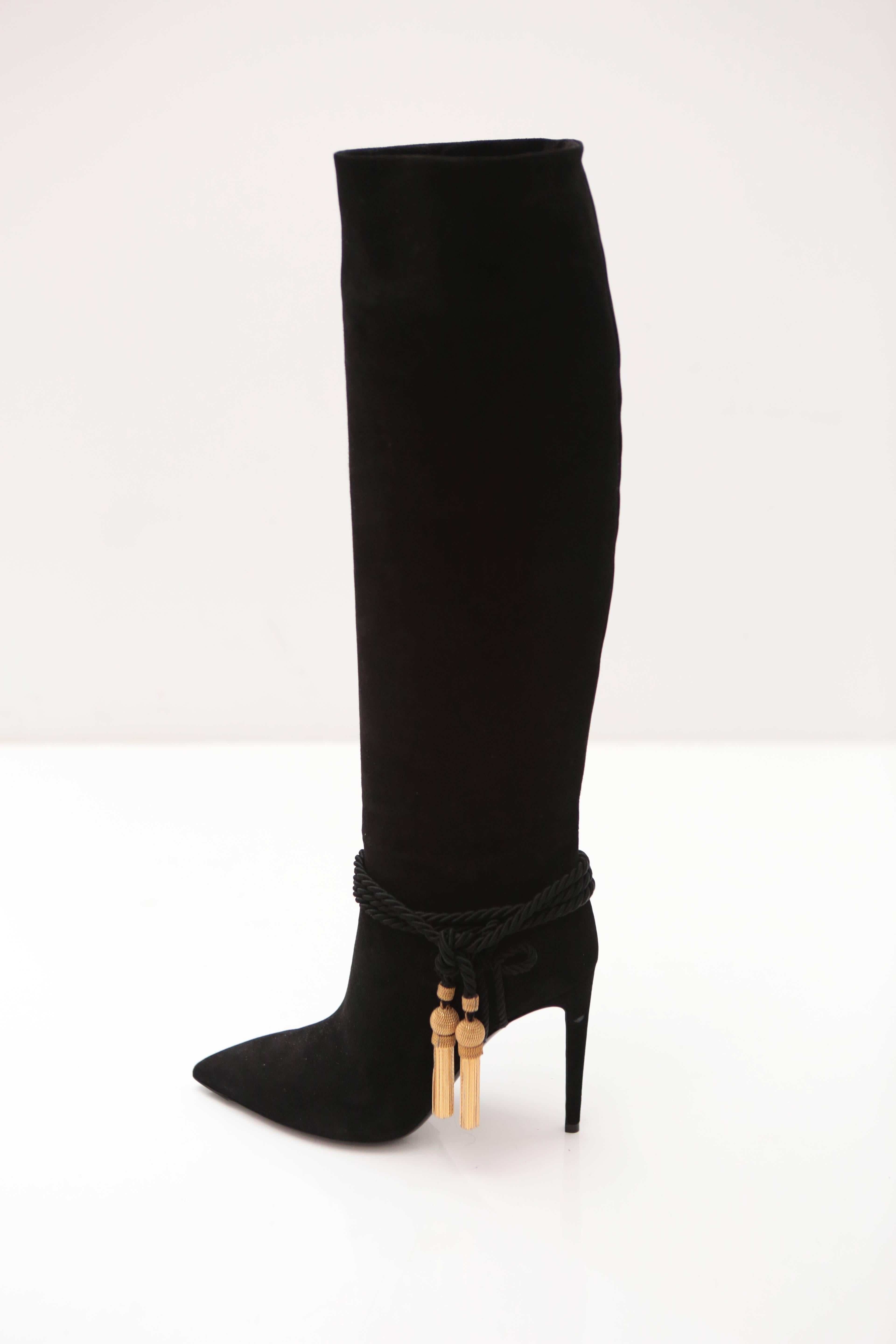 Suede Knee High Boots get tied up with a gold tassel to sass up any look.