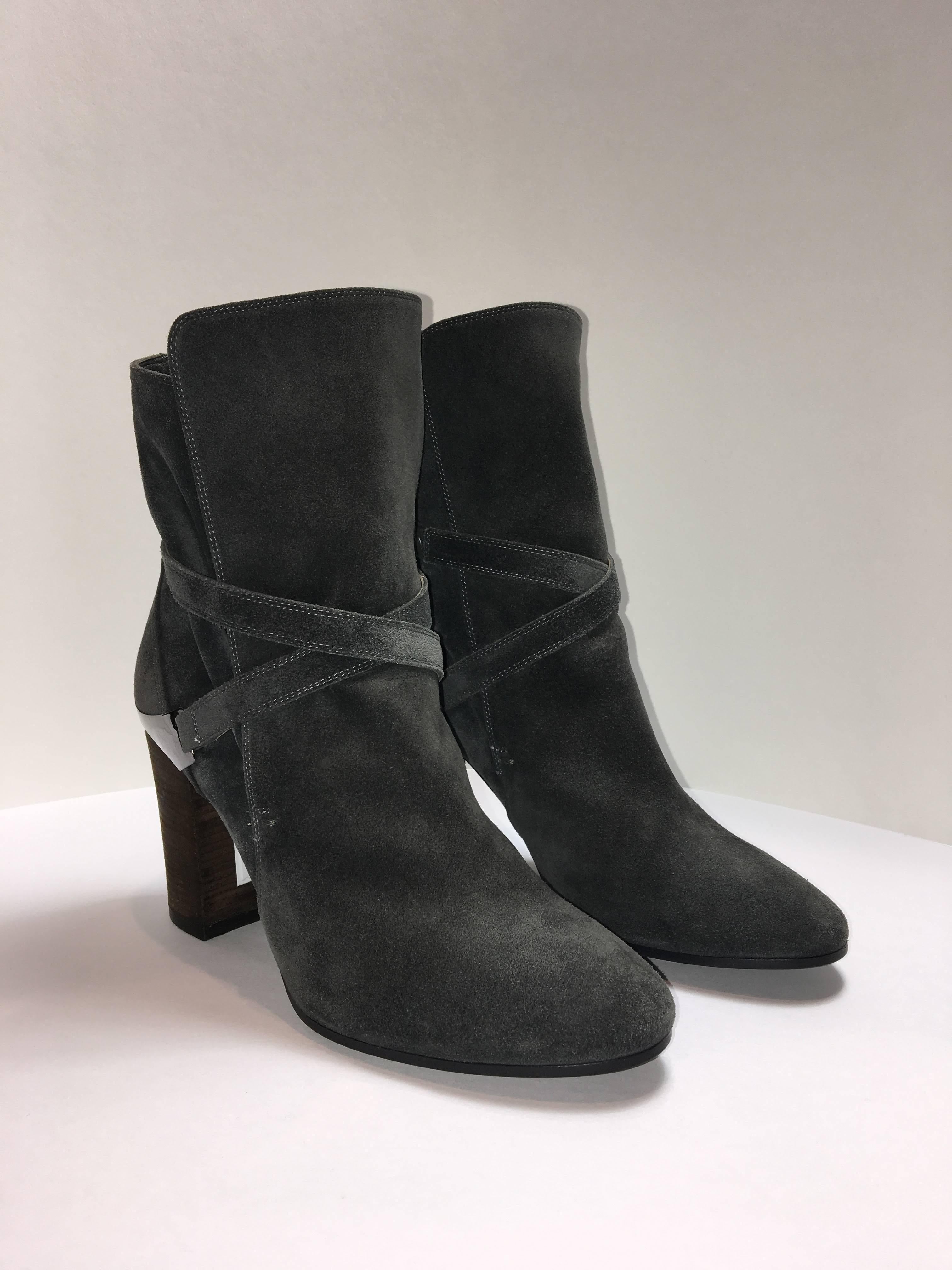 Very lightly worn Lanvin booties show little wear on their matieral and sole. Criss-cross detail wraps around ankle and synches at heel. Contrasting stitching along seams.
