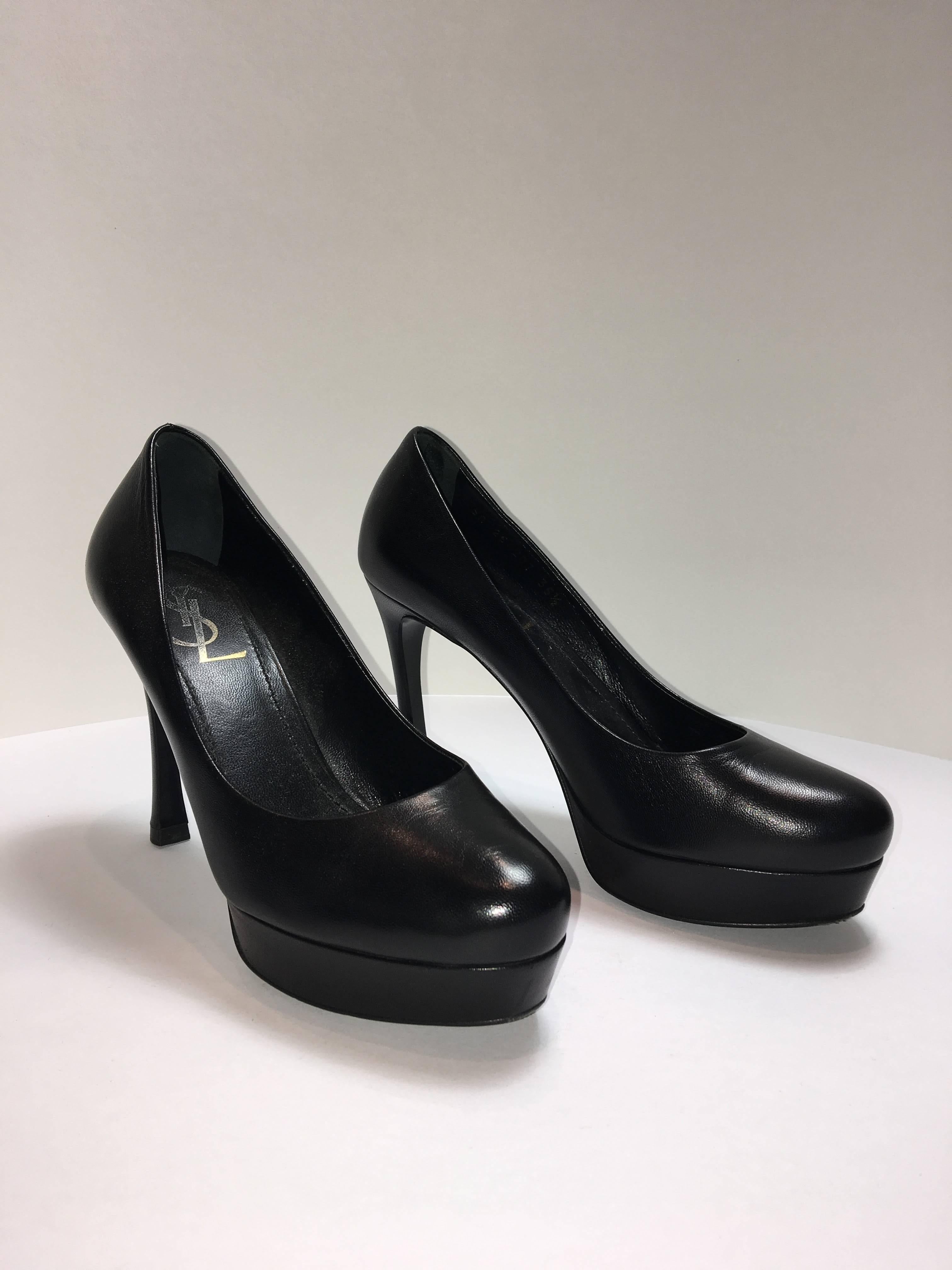 YSL pumps with platform sole. Made of black leather with a rounded toe. These heels show very light wear. 