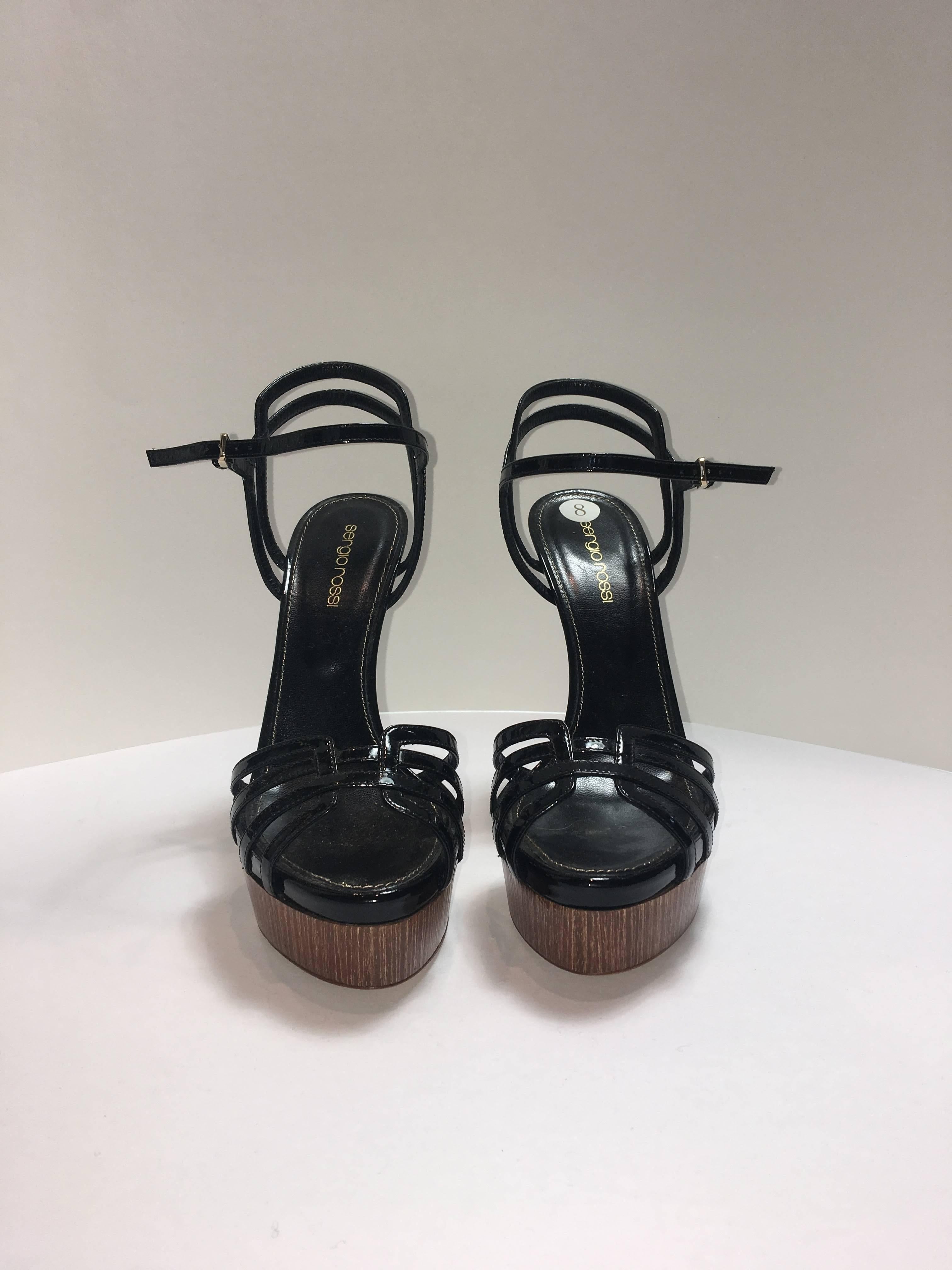 Sergio Rossi heels  in black Patent Leather. Sky high wood platforms in Size 38 with cut out detail.