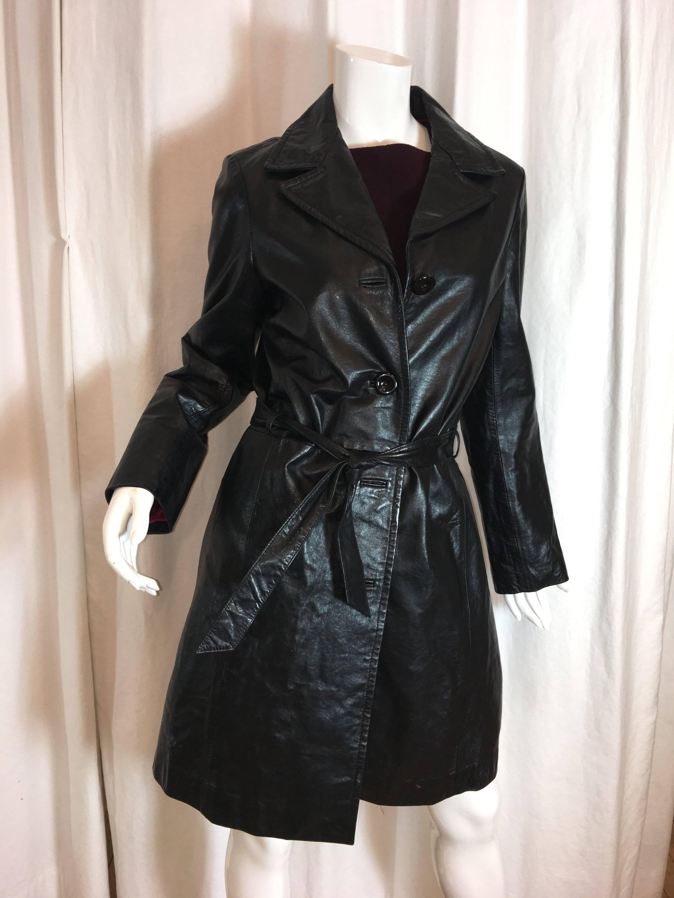 Katayoni Adeli Black Leather Belted Coat with Red Lining. Four Button Front with one missing. 
