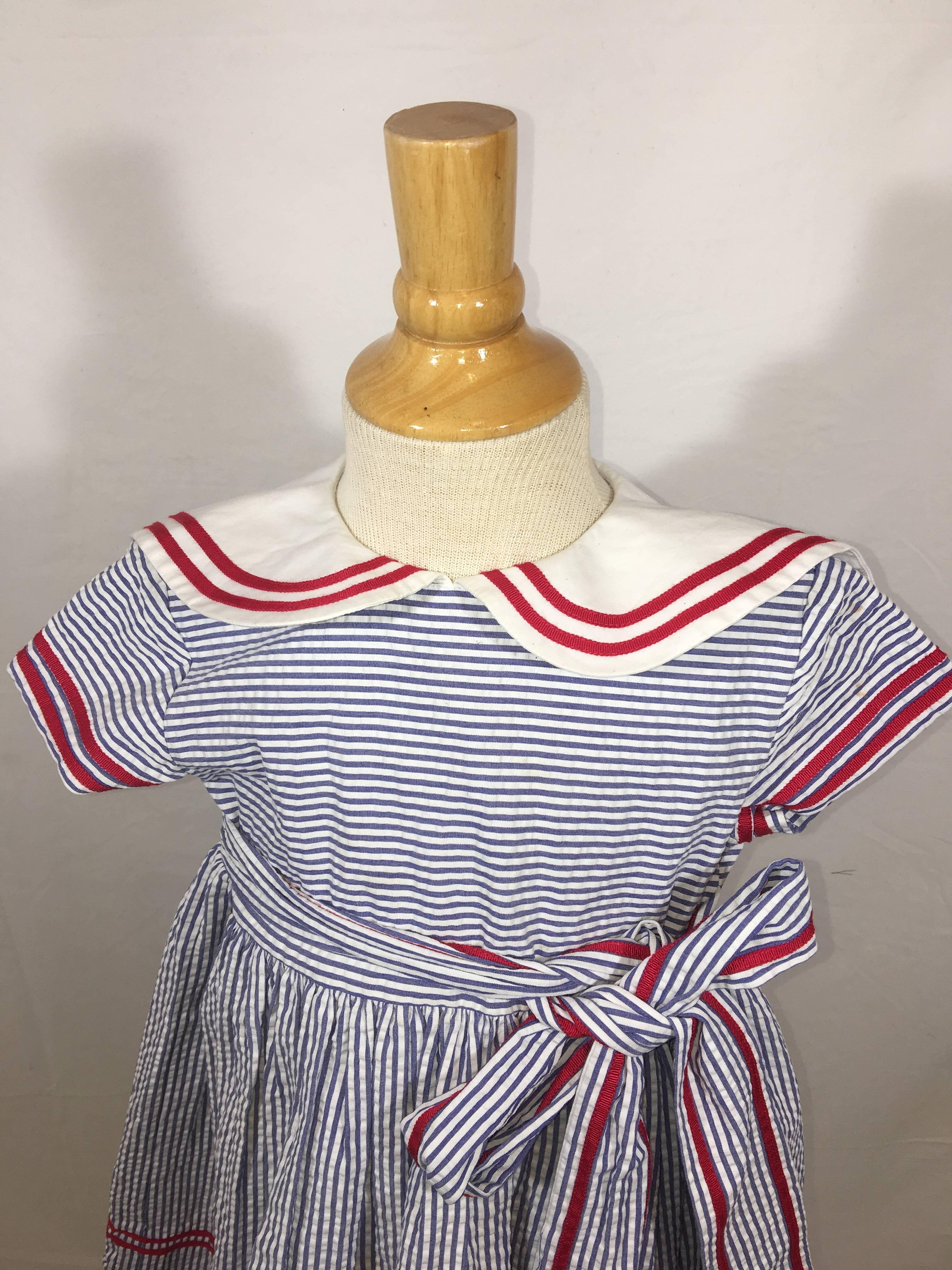 Kids Oscar de la Renta Short Sleeve Dress. White and Blue Striped with Peter Pan Collar and Red Details. Ties at Waist.