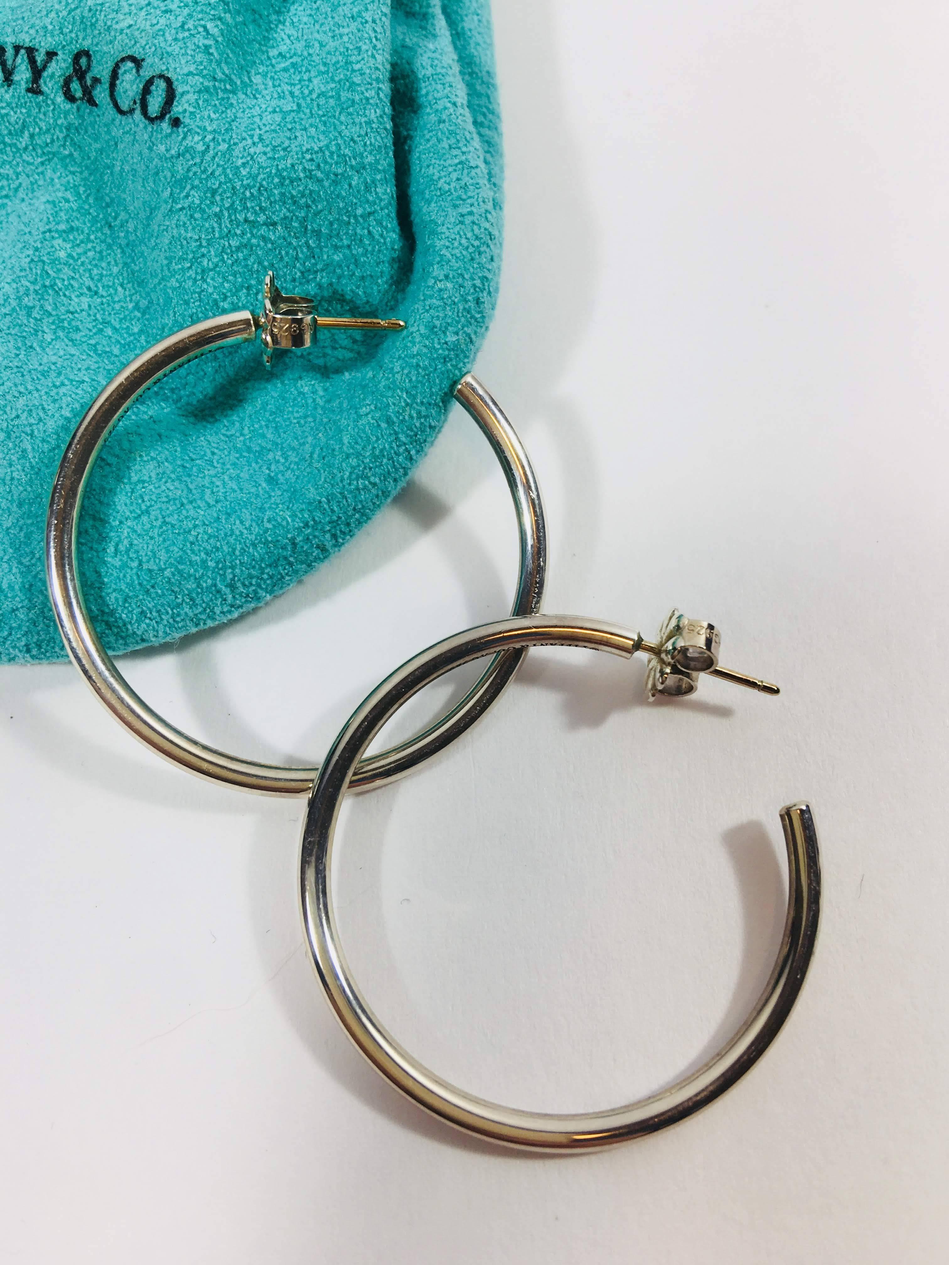 Tiffany & Co. Sterling Silver Small Hoop Earrings with Posts and Friction Backs. Comes with Original Bag and Cleaning Manual. 