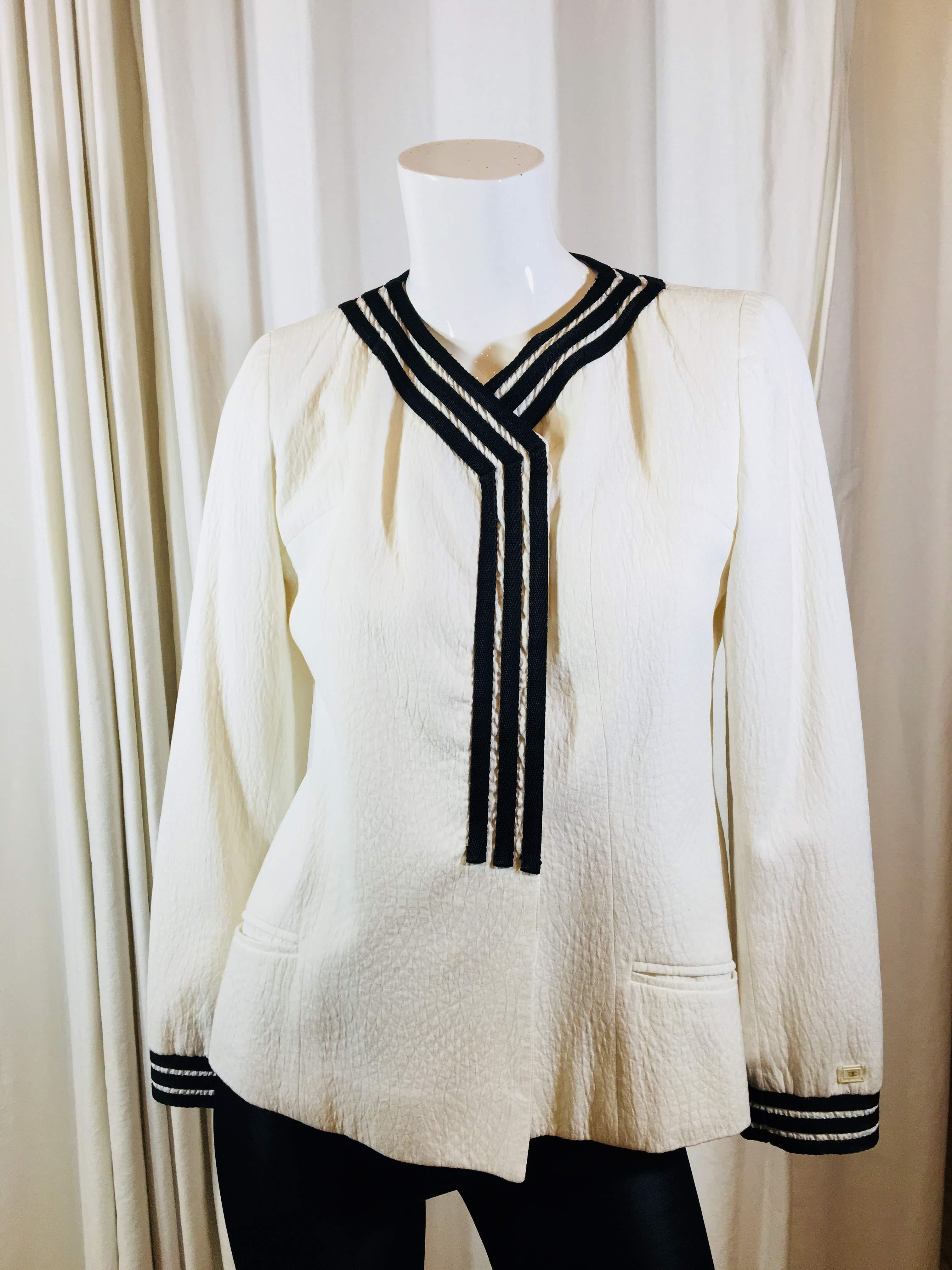 Chanel White Off-Center Jacket with Black and White Stripe Trim on Neckline and Cuffs, Textured Black Pants with Front Slit Pockets.