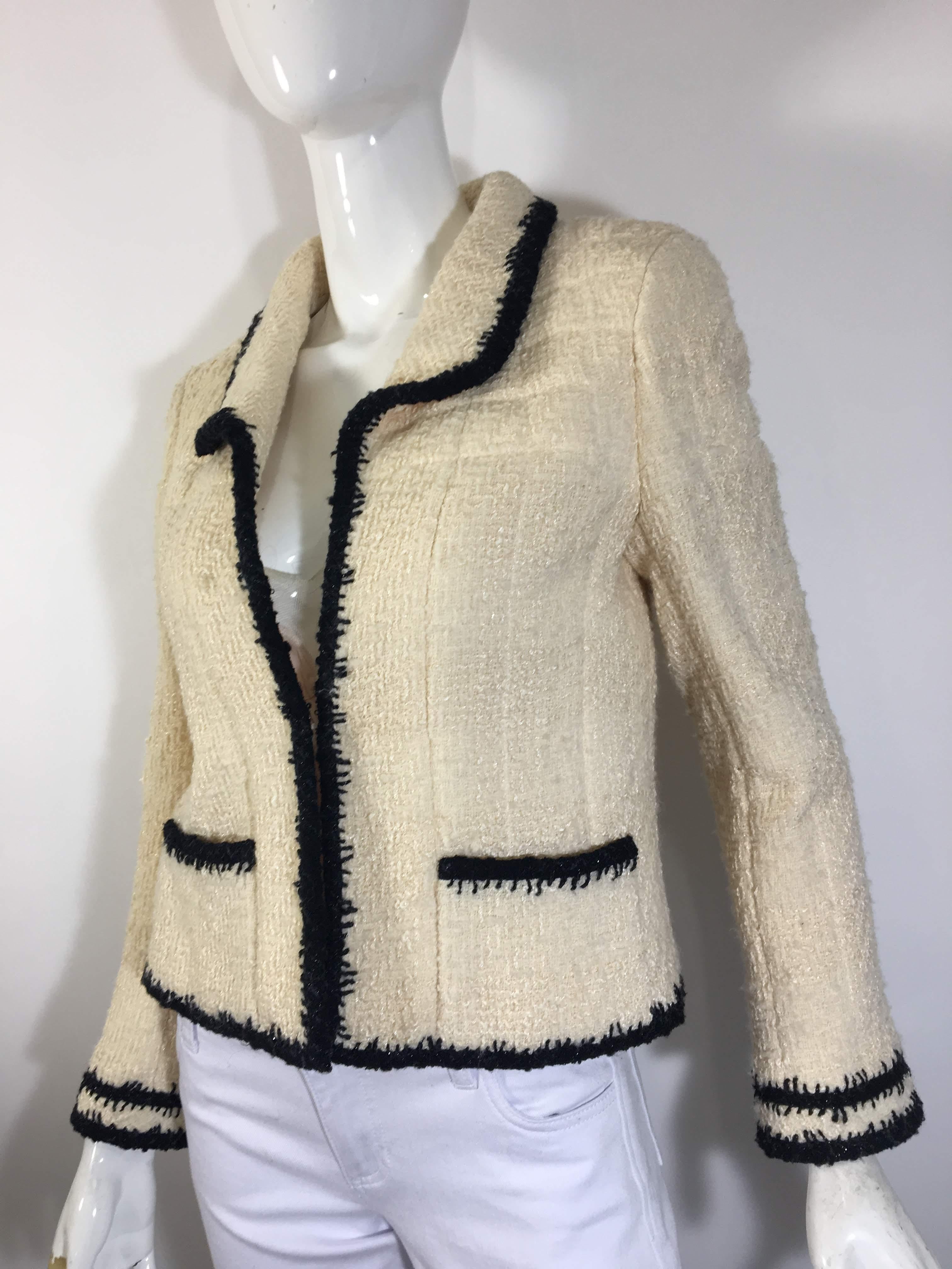 Chanel Cream Textured Wool/Silk Jacket 
Collar with Deep V-Front and Two Front Pockets
Black Trim - Double Striped on Sleeves
Embellished Buttons with Jewels and Chanel Logo.
Silk Lining
Made in France- Size 40