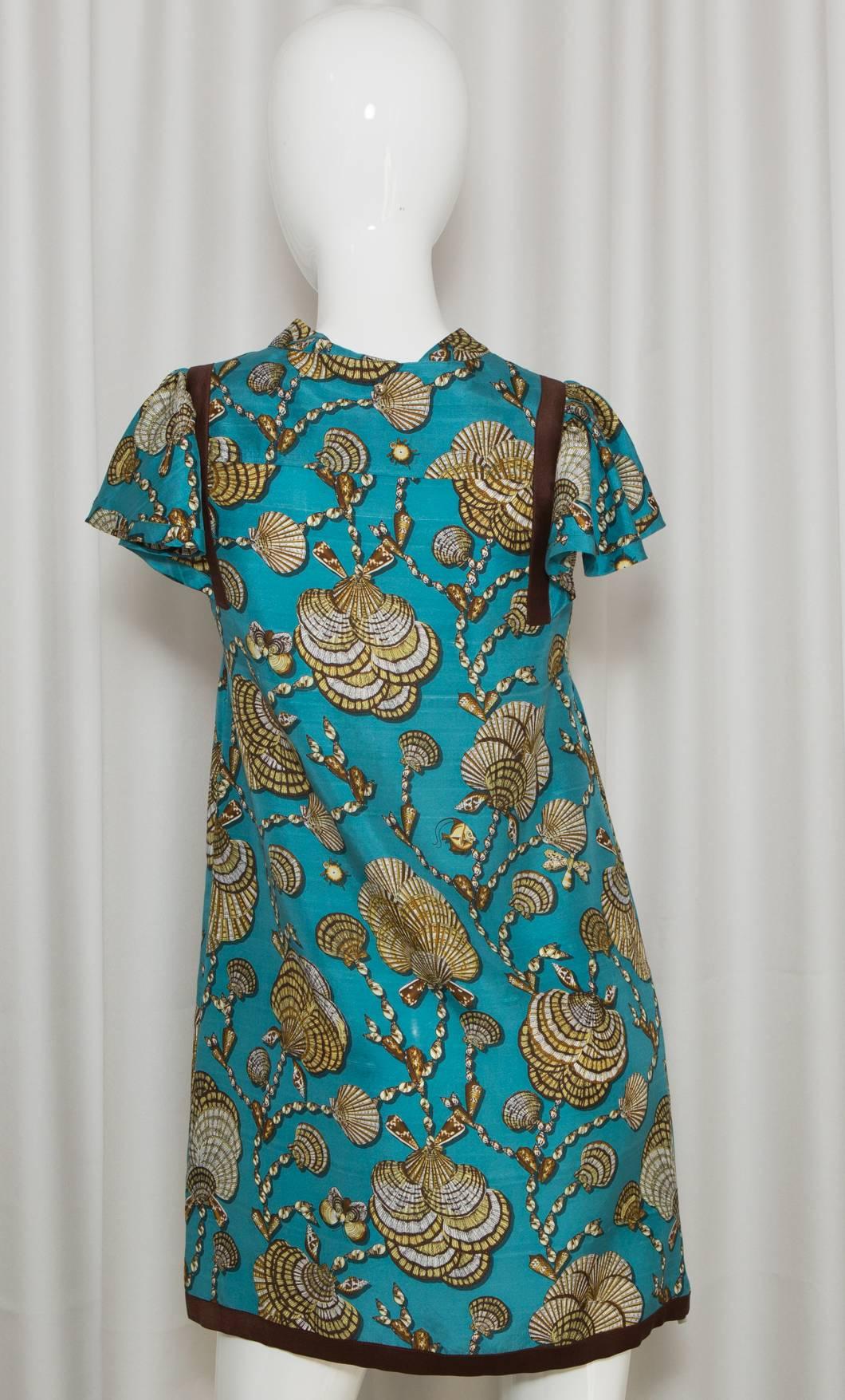 Short Sleeve turquoise tunic silk dress with tan shell pattern and neck tie closure.