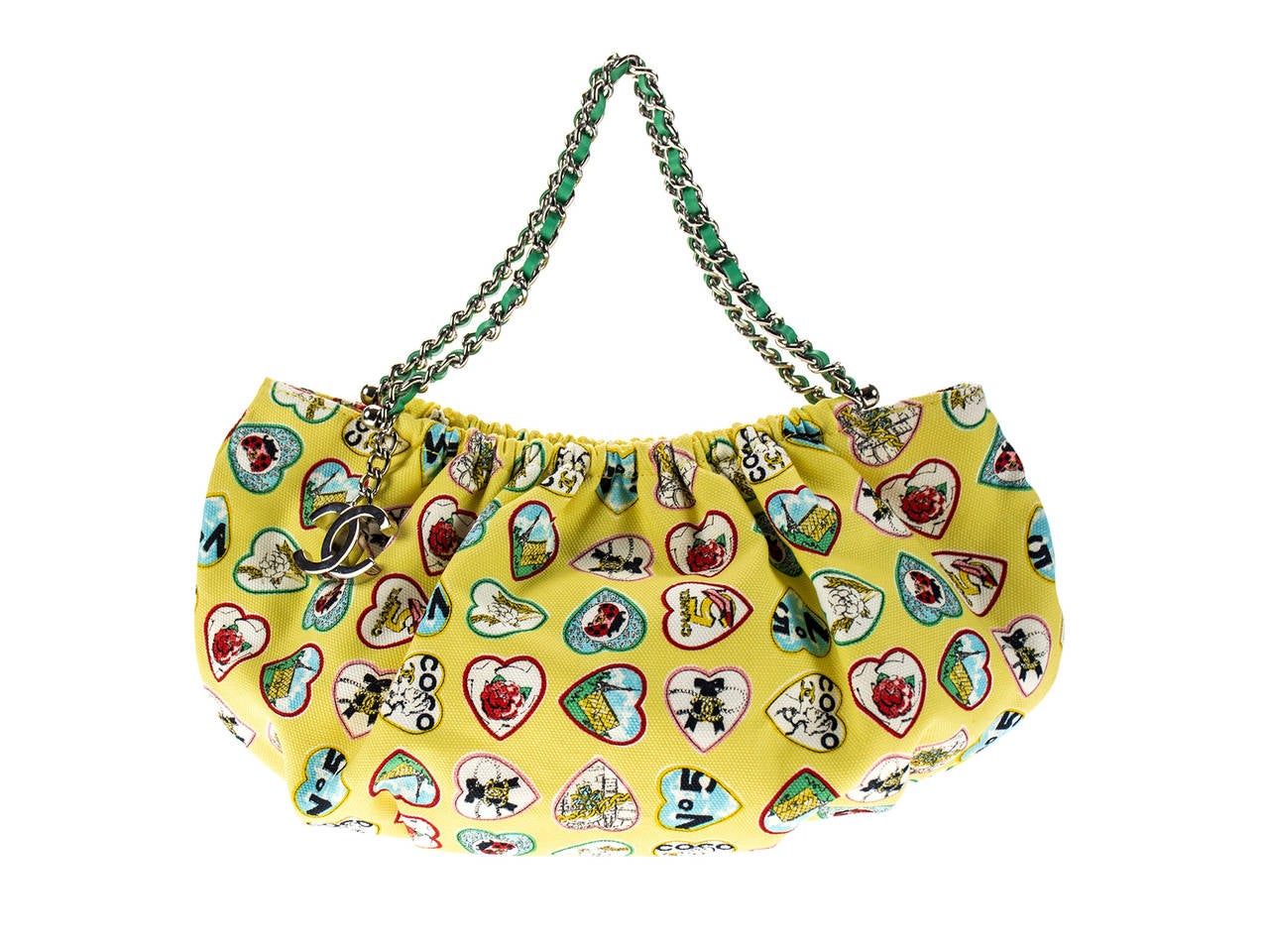 Bright yellow color of this Chanel hobo bag is so perfect for the summer. Canvas imprinted with hearts featuring jewelry and pendant pieces so admired by Coco Chanel. Two classic leather and chain straps drop 4