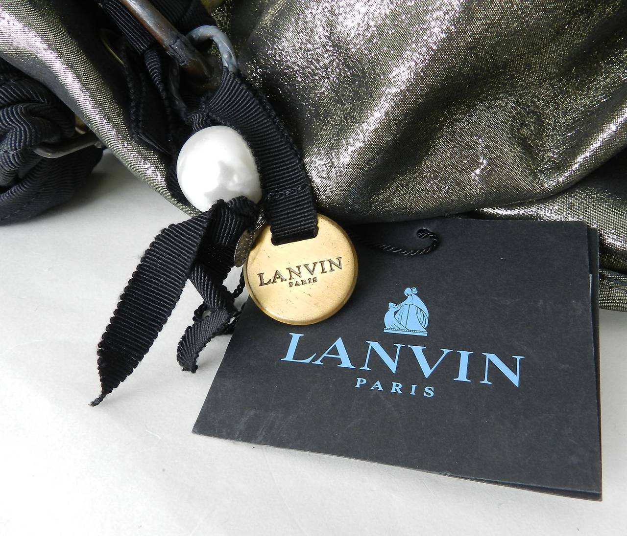 Lanvin Polisson bag. Large size with metallic coated leather and black fabric handles. Very roomy interior, small zip pouch, pearl and metal logo keychain. Excellent previously owned condiiton. Body measures about 20 x 15 x 8