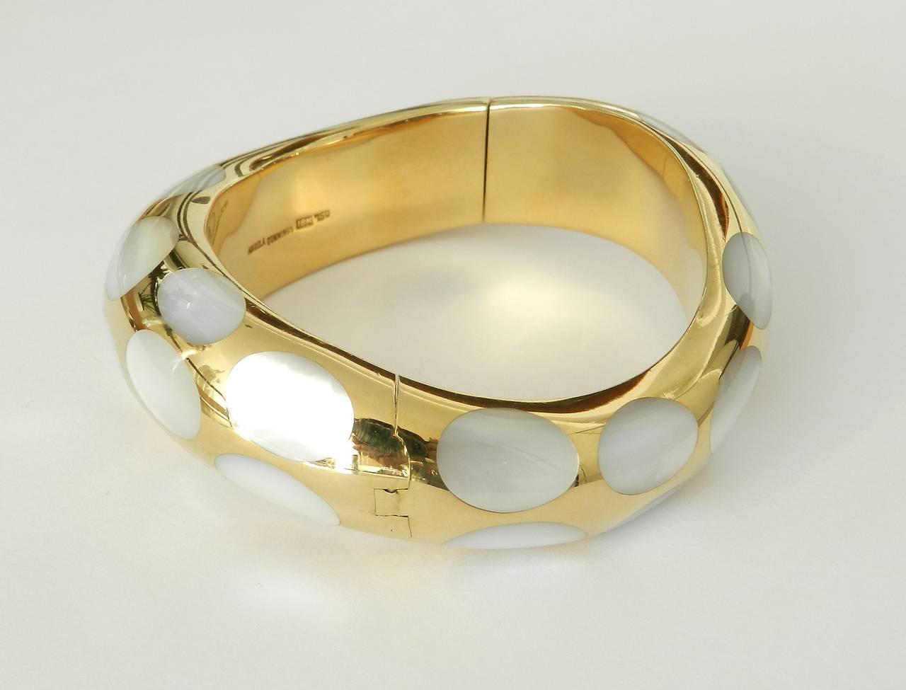 Angel Cummings 18k gold and mother of pearl inlay hinged bangle bracelet. Excellent condition. Hallmarked Angela Cummings, 18k, 750. Bangle measures 5/8