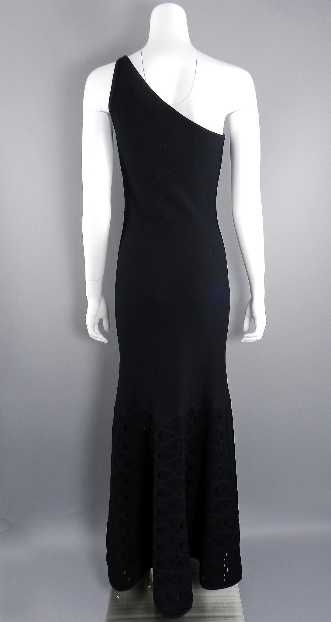 Chanel long black stretch jersey one shoulder gown. Clingy stretch fabric composed of 67% rayon, 33 poly. Skirt hem flares out with pierced mesh design. Excellent condition. Tagged size FR 38 (USA 6). To fit 34