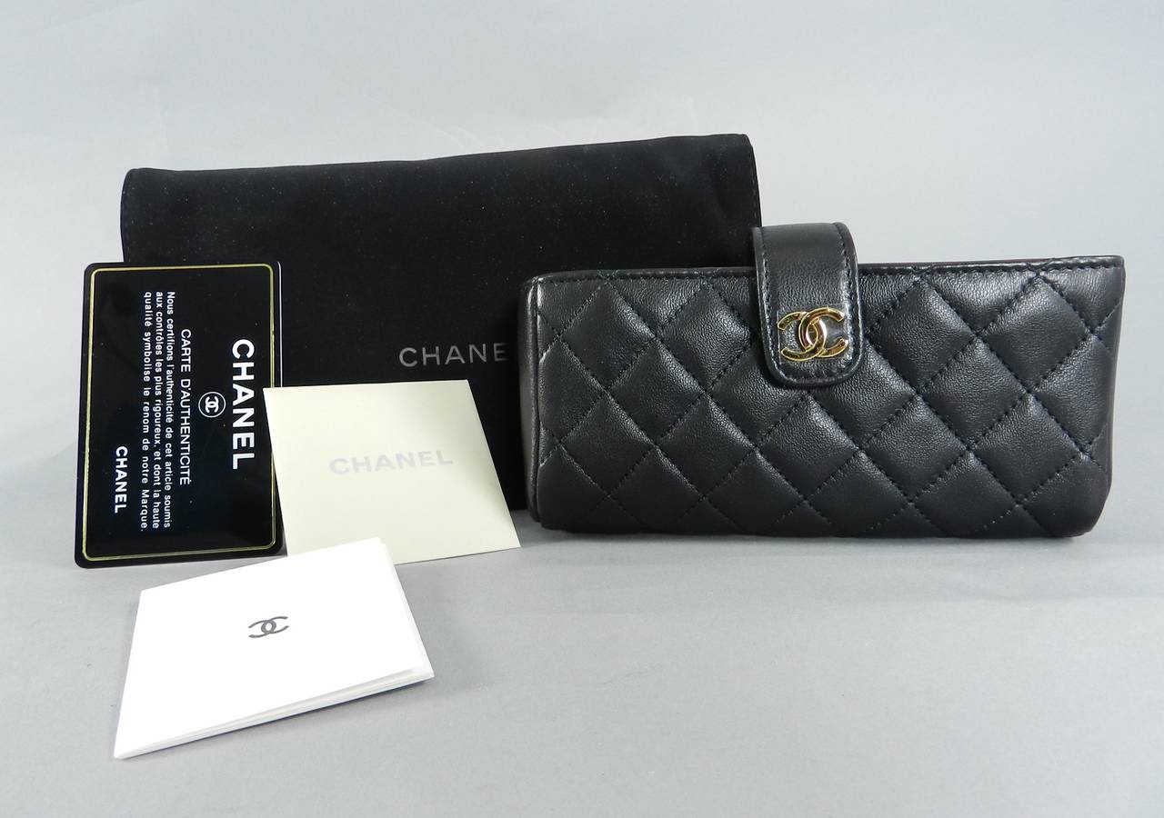 Chanel small black quilted leather clutch. Can hold and phone, lipstick and cards.  New unused condition with plastic still on the CC logo. Date code is 19 series for current 2015 season. Comes with card, care papers, and duster. Measures 6