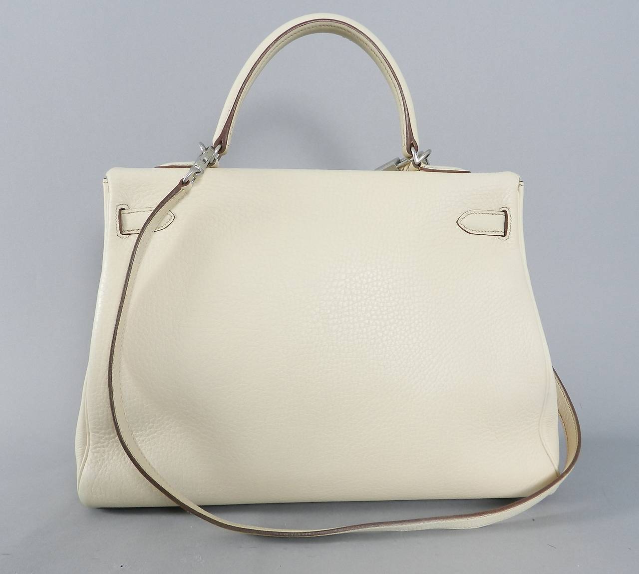 Hermes Kelly 35 blanc casse color with brushed palladium hardware. This bag just came back from Hermes spa and is in excellent previously owned condition with no outstanding flaws to note. The metal hardware still has plastic cover on it from being