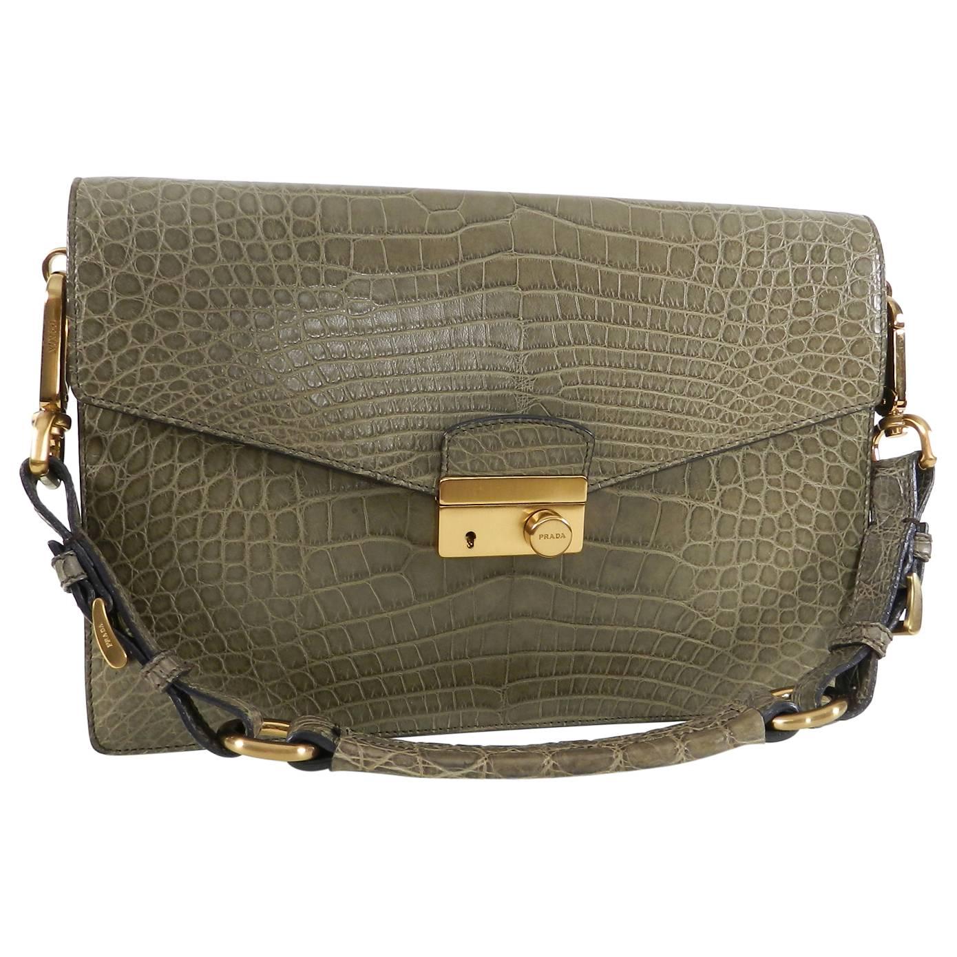Prada Crocodile Sound Bag with Matte Gold Hardware.  Short shoulder strap, front lock, burgundy leather lined interior.  Body of bag measures about 11.75 x 8 x 3” with a 7” strap drop.  Excellent pre-owned – only carried a few times.  Includes