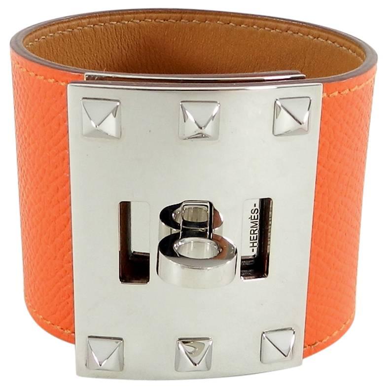 Hermes Kelly Extreme Orange Epsom Leather Cuff Bracelet.  Palladium hardware with turn clasp and pyramid studs.  Excellent pre-owned condition with no scratches or damage. No duster or box. 48mm wide.  Date stamp R in square for year 2014.  Size