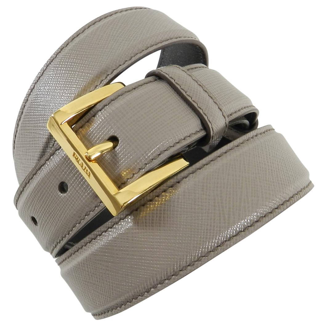 Prada Taupe Saffiano Leather Belt with Gold Buckle.  Measures 1-⅛” wide and is marked a size 36/90.  The belt has holes from 34” to 37.5”.  Excellent clean pre-owned condition.
