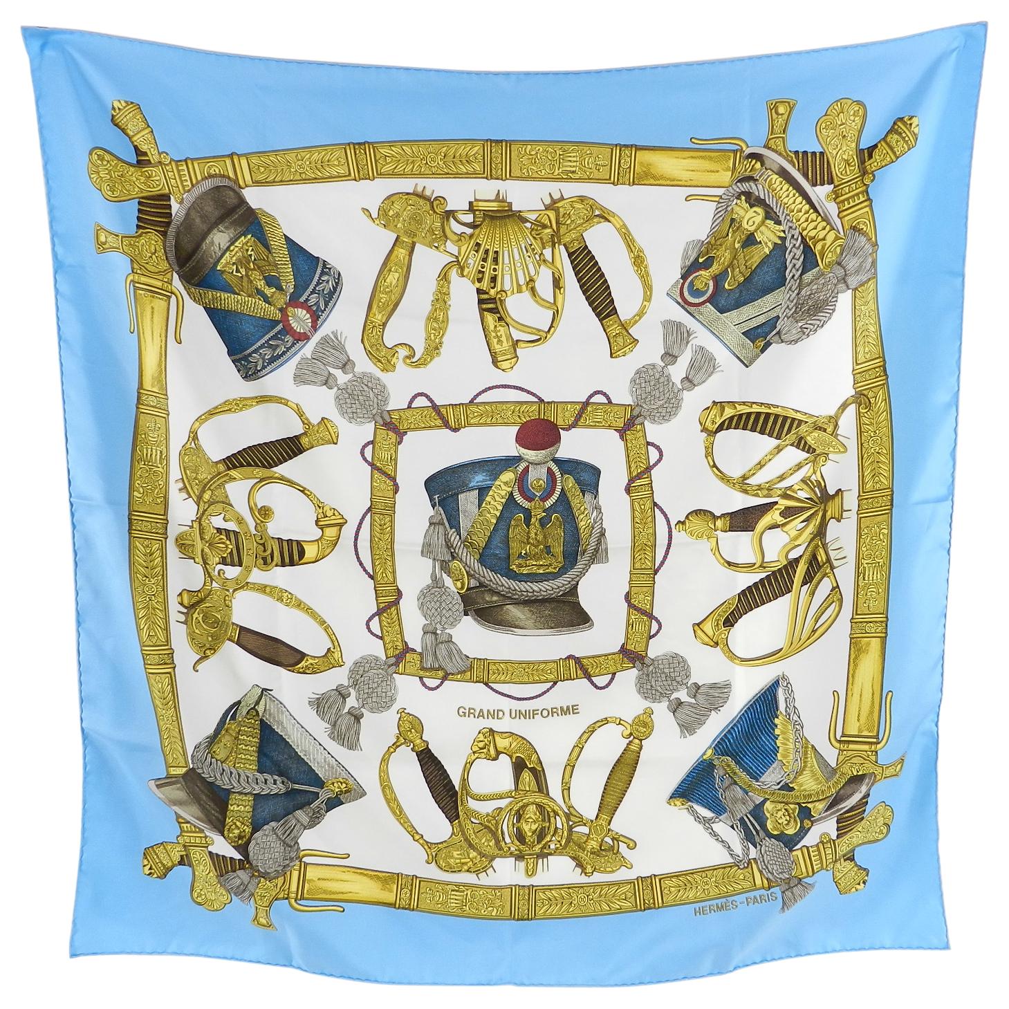 Hermes Grand Uniforme 90cm Scarf.  Designed by J. Metz. 90cm silk twill with hand rolled and stitched edges. Design with military hats in light baby blue, white, and yellow.  Excellent pre-owned condition. No box. 

