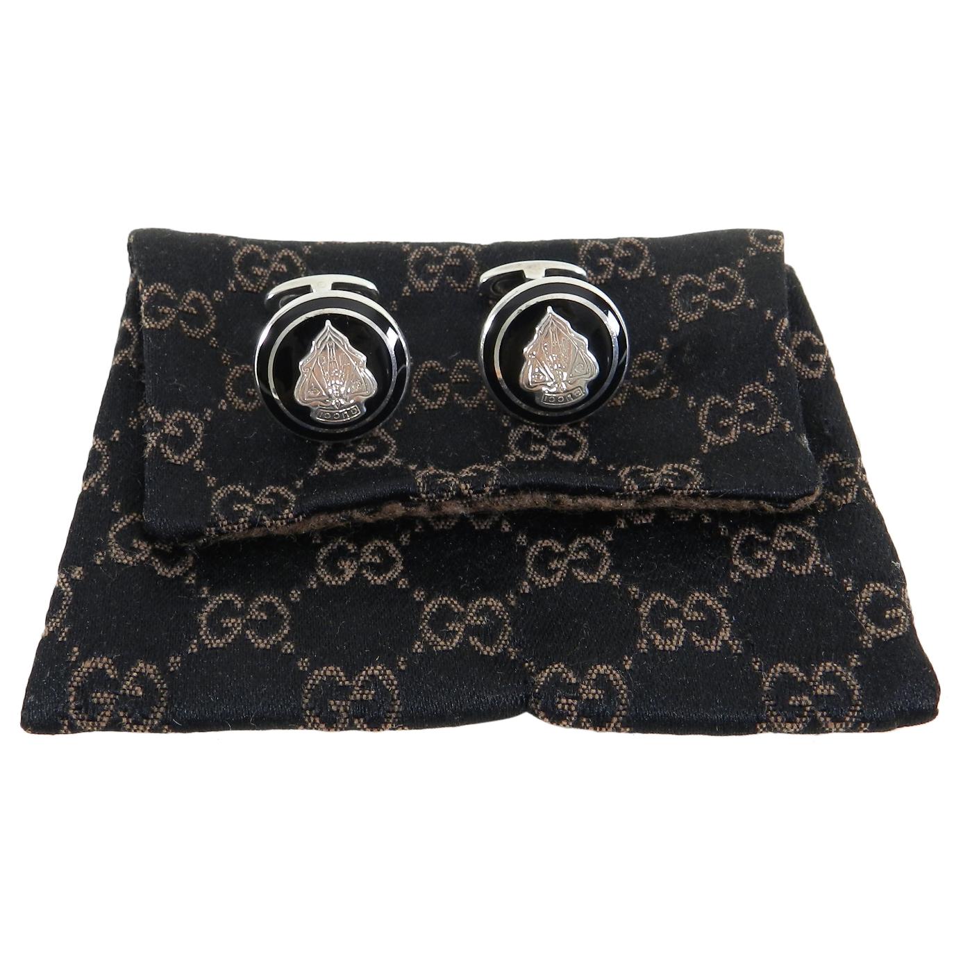Gucci Sterling Silver Black Enamel Crest Cufflinks.  Round design with Gucci logo crest and black enamel. Fully hallmarked for 925 sterling silver.  Includes pouch.  Measures 0.75