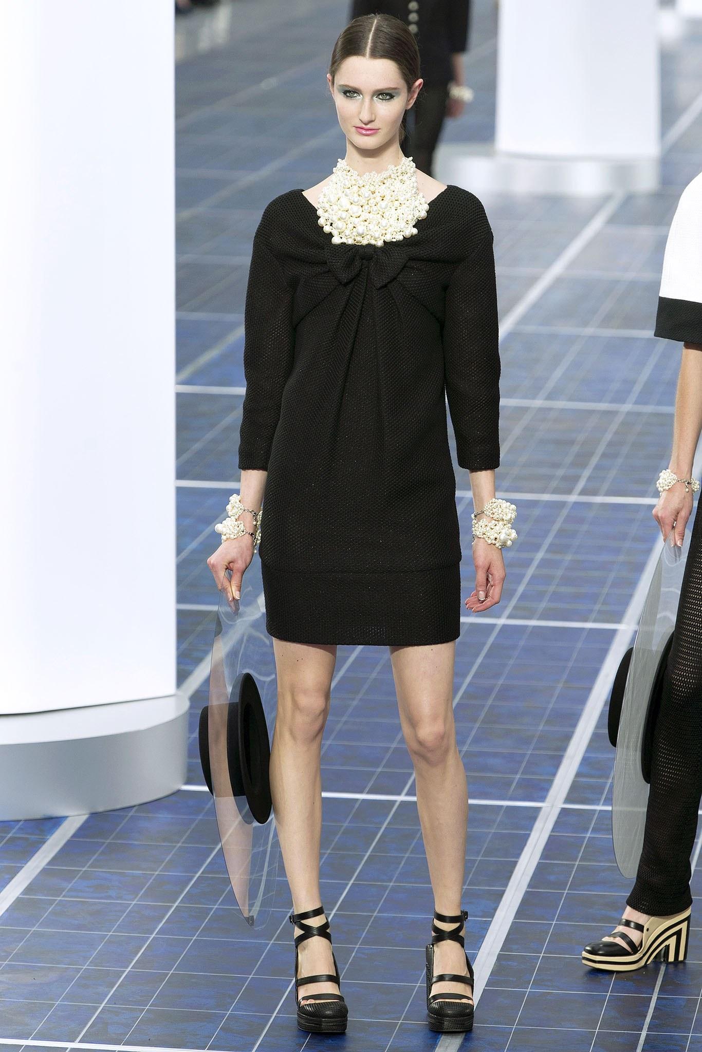 Chanel Spring 2013 Runway Black Woven Dress with Bows.  Deep V-neckline at front and back with bow accent.  Centre back invisible zipper, bracelet length sleeves,  side hip pockets on seam.  Open weave design with a slight shimmer.  Marked size FR42