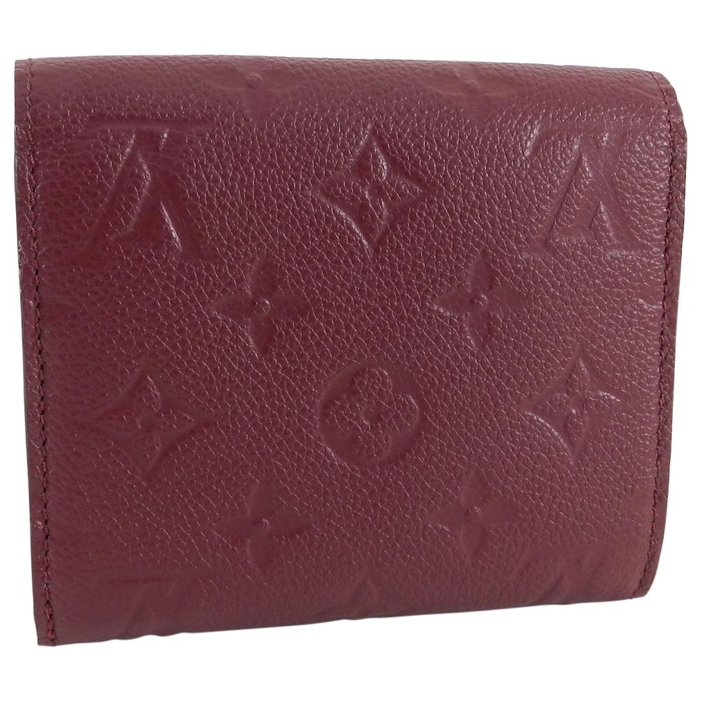 Louis Vuitton Monogram Empreinte Ariane Wallet Raisin. Current retail price $830 USD and $965 CAD.  Trifold wallet with 12 card slots, zippered coin pocket, 1 bill pocket, 1 window pocket, 2 flat pockets.  Monogram empreinte cowhide leather in