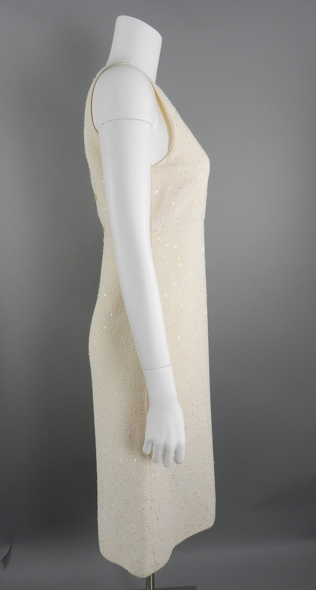 Chanel 2000 Cruise collection sleeveless shift dress. The dress is ivory with a hint of shell pink color. 5 clear CC buttons at back, zipper, and lined in silk. Excellent previously owned condition. Tagged size FR 38 (USA 4/6). To fit 33/34