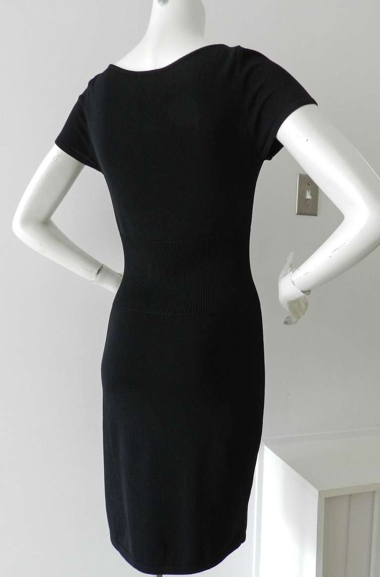 Chanel classic black stretch jersey dress with short sleeves. Pockets at front, vertical ribbed waistline, CC logo plaque at left hip. Excellent condition - worn once. Tagged size Chanel 38 (USA 6). To fit 34