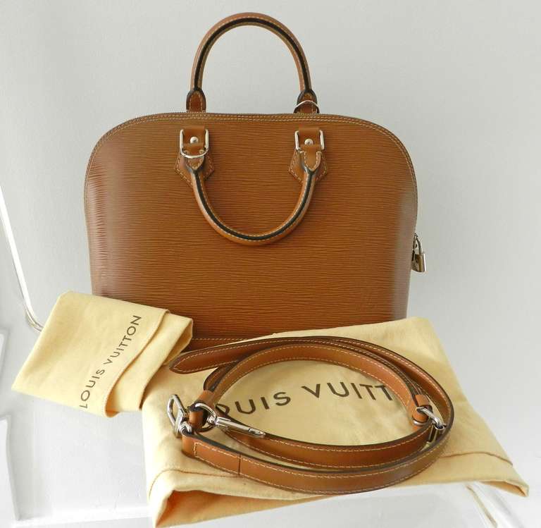 Louis Vuitton epi alma PM with strap in moka brown. Straps were originally sold separately. Comes with lock and key, strap, and duster.  Excellent previously owned condition. Body measures 9.5 x 14 x 6.25