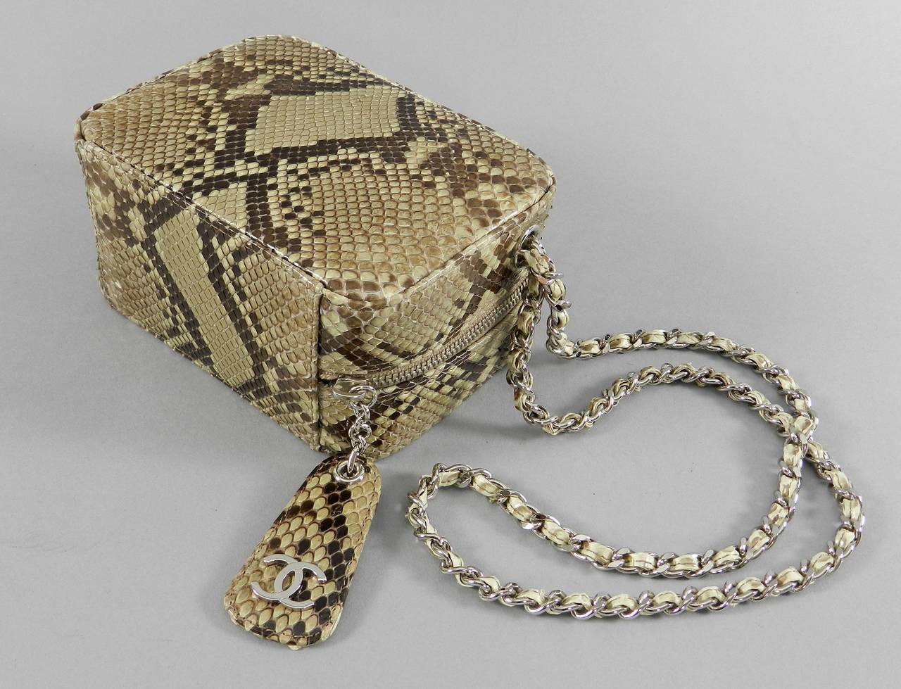 Chanel vintage 2000 fall runway collection python box wristlet bag. Still has original tags and was never used. Mint! Excellent clean condition on both interior and exterior. Silvertone hardware with CC logo zipper pull, chain looped strap, and