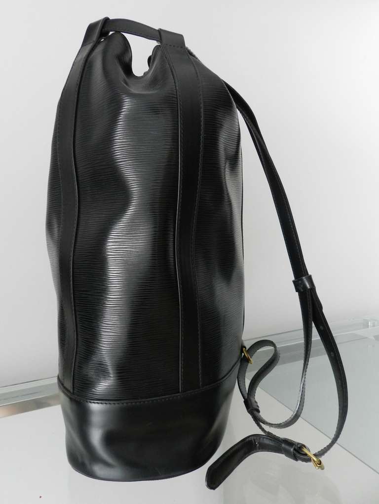 Louis Vuitton black epi leather Randonnee drawstring backpack. Large GM size.  Excellent unused condition and date stamped for March 1987! Purchased and stored away for years. Interior is in unused condition.

Shipping prices provided are for