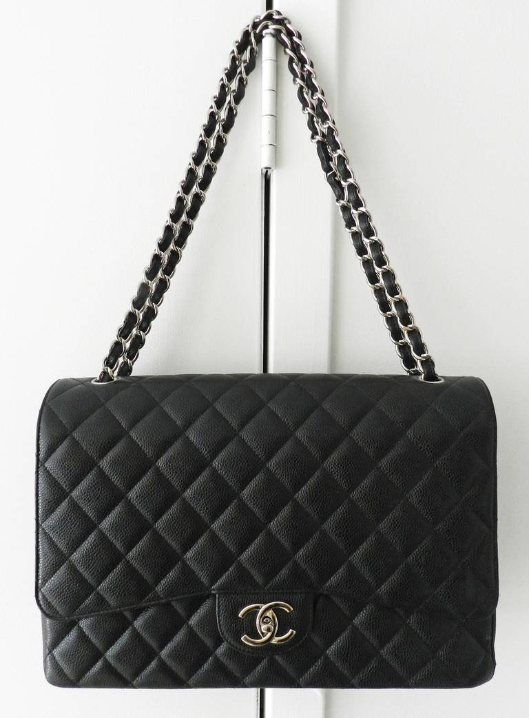 Chanel black caviar leather Maxi flap bag in silvertone hardware. Excellent previously owned condition. Body of bag measures 13 x 8.5 x 3.5