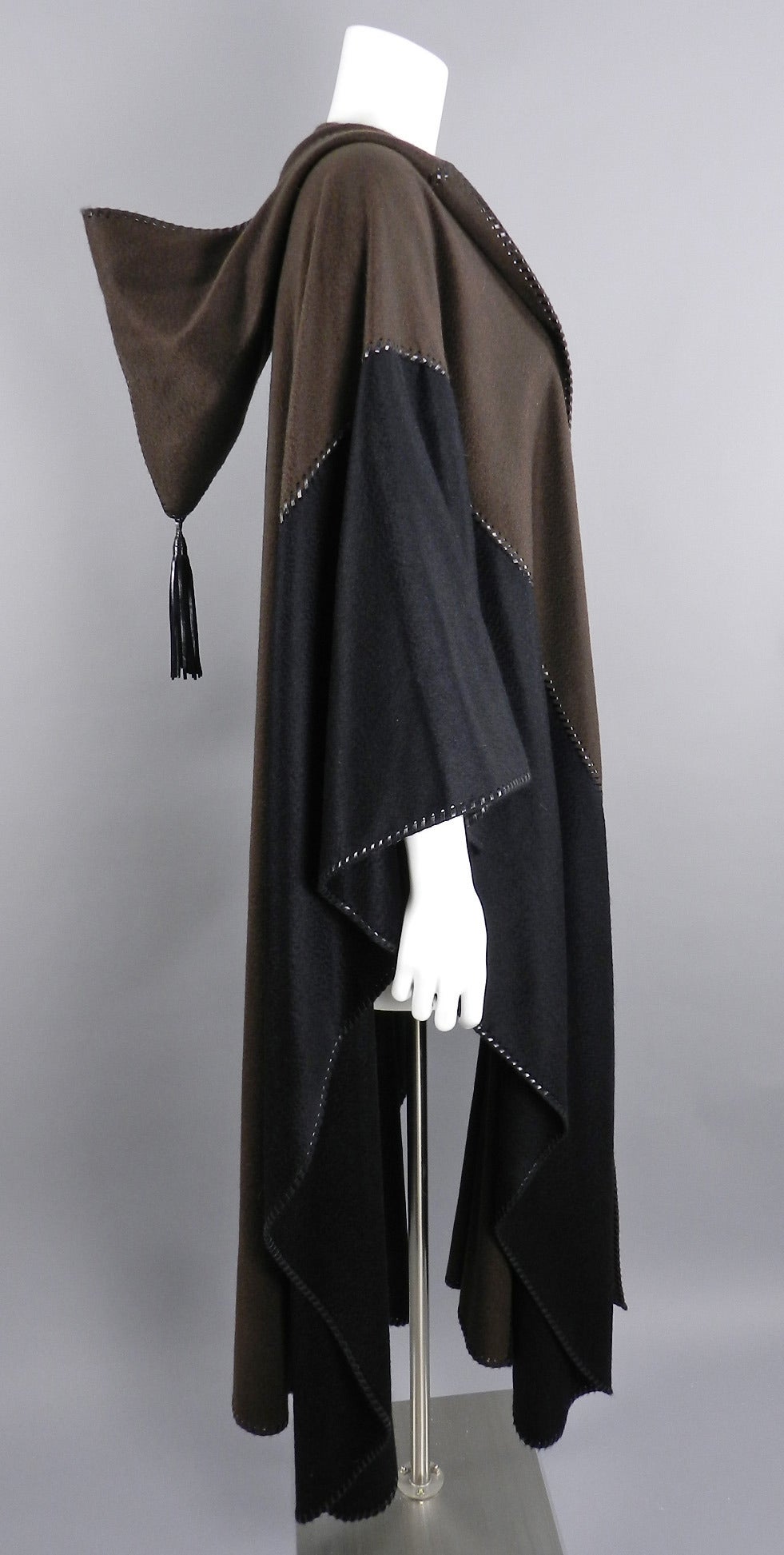 Yves Saint Laurent Haute Couture 100% cashmere Nomad cape. Circa 2003.  Originally purchased on the Rue de Faubourg-St-Honore. Whipstitched leather edges and tassel on hood. Excellent clean condition. Free size. Back neck to hem is 49