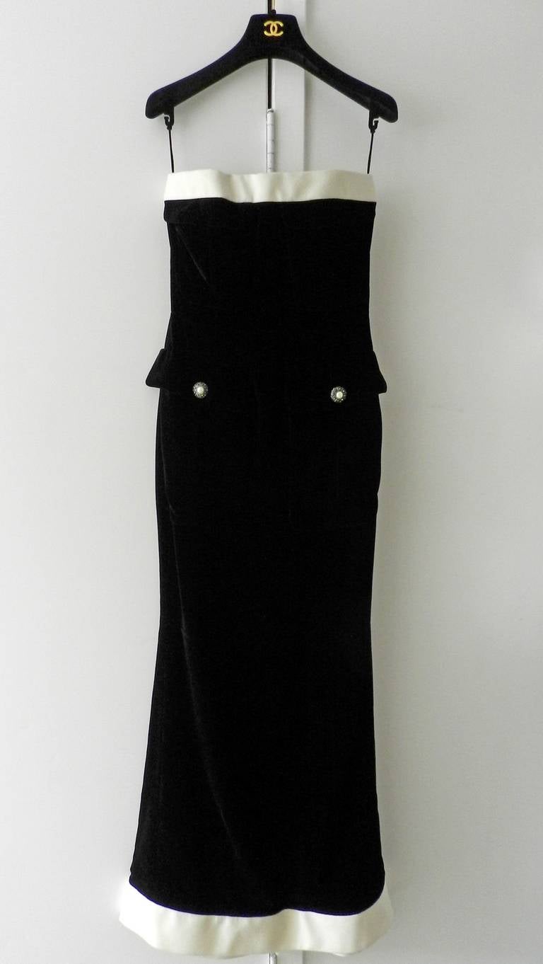 Chanel strapless black velvet gown with matching jacket. Gown is trimmed in white and has 2 front hip pockets with pearl buttons. Jacket is cropped, has white collar trim, and 3/4 length sleeves. Excellent condition. Tagged size FR 38 (USA 6). Dress
