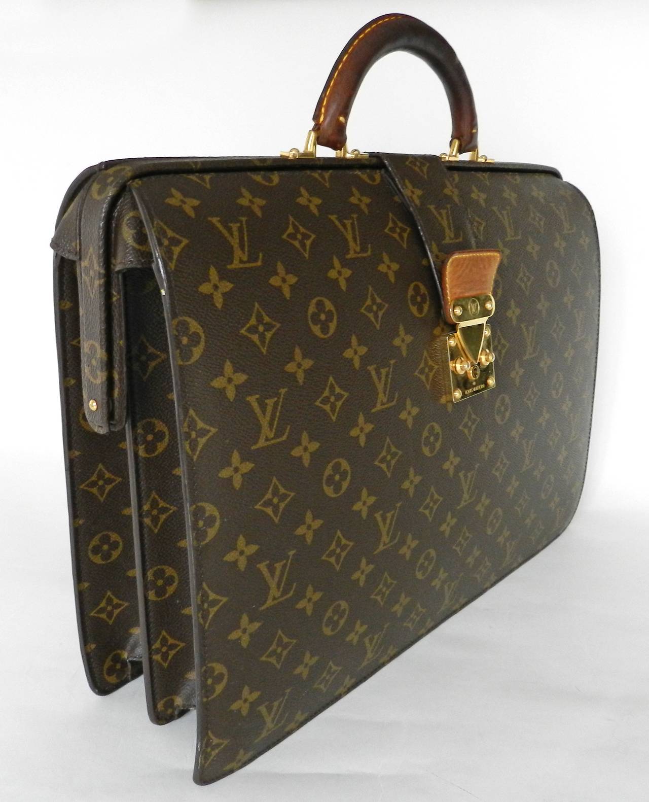 Louis Vuitton discontinued rare Serviette Fermoir monogram briefcase. Date code for year 2006. Exterior including corners is in excellent condition. Interior has scratching and scuffs as pictured and darkening of leather on handle. Keys and duster