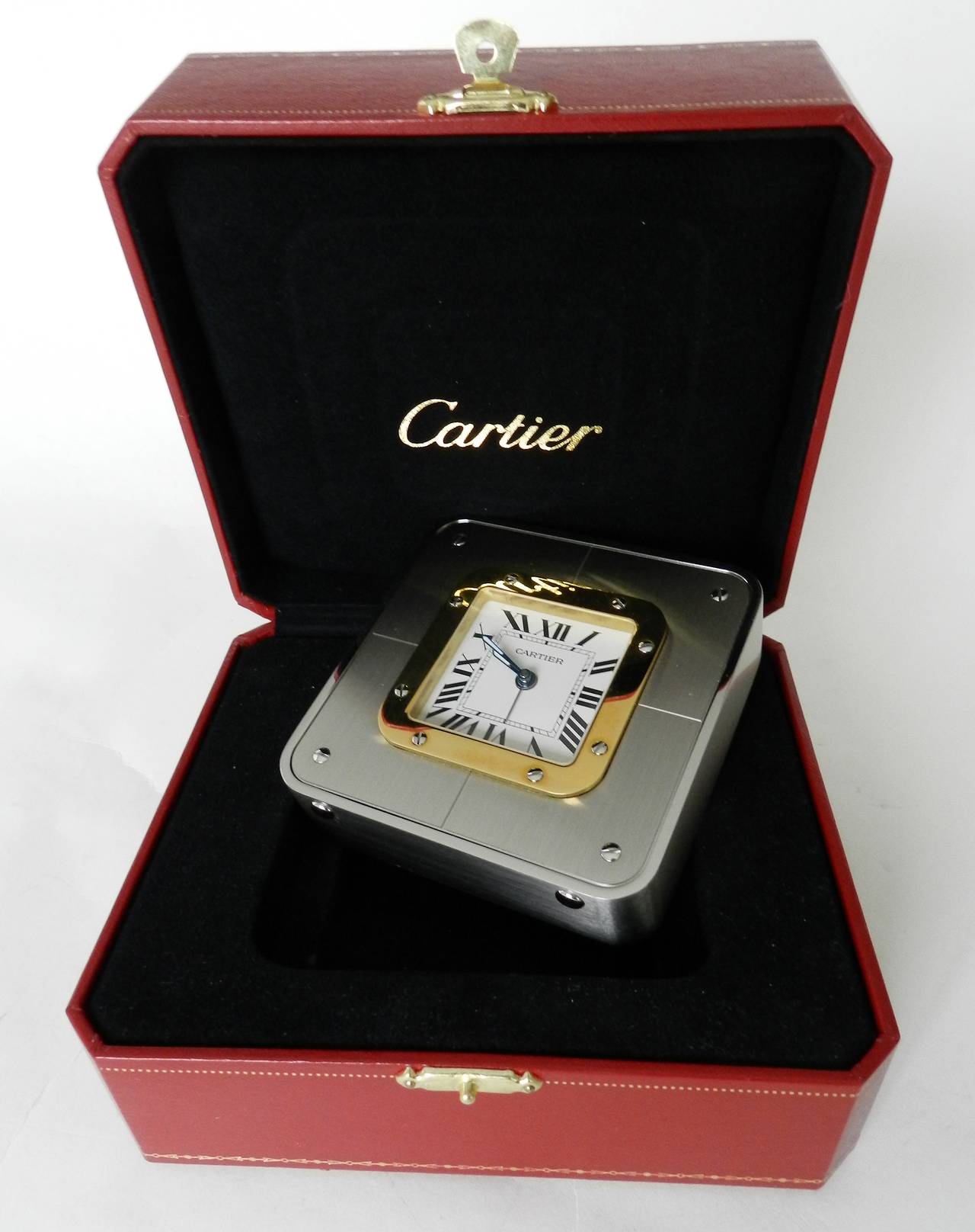 Cartier Santos desk clock. Brushed silvertone and gold with white face, roman numerals, alarm function, original box. Measures 3.5