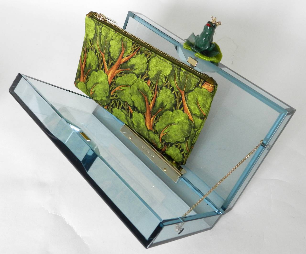 Charlotte Olympia frog prince pandora perspex clutch bag. Transparent blue acrylic body with green enamel frog clasp, green forest zipper fabric insert, magnetic closure. Original box, unused. Body measures 7.5 x 4.25 x 1.75