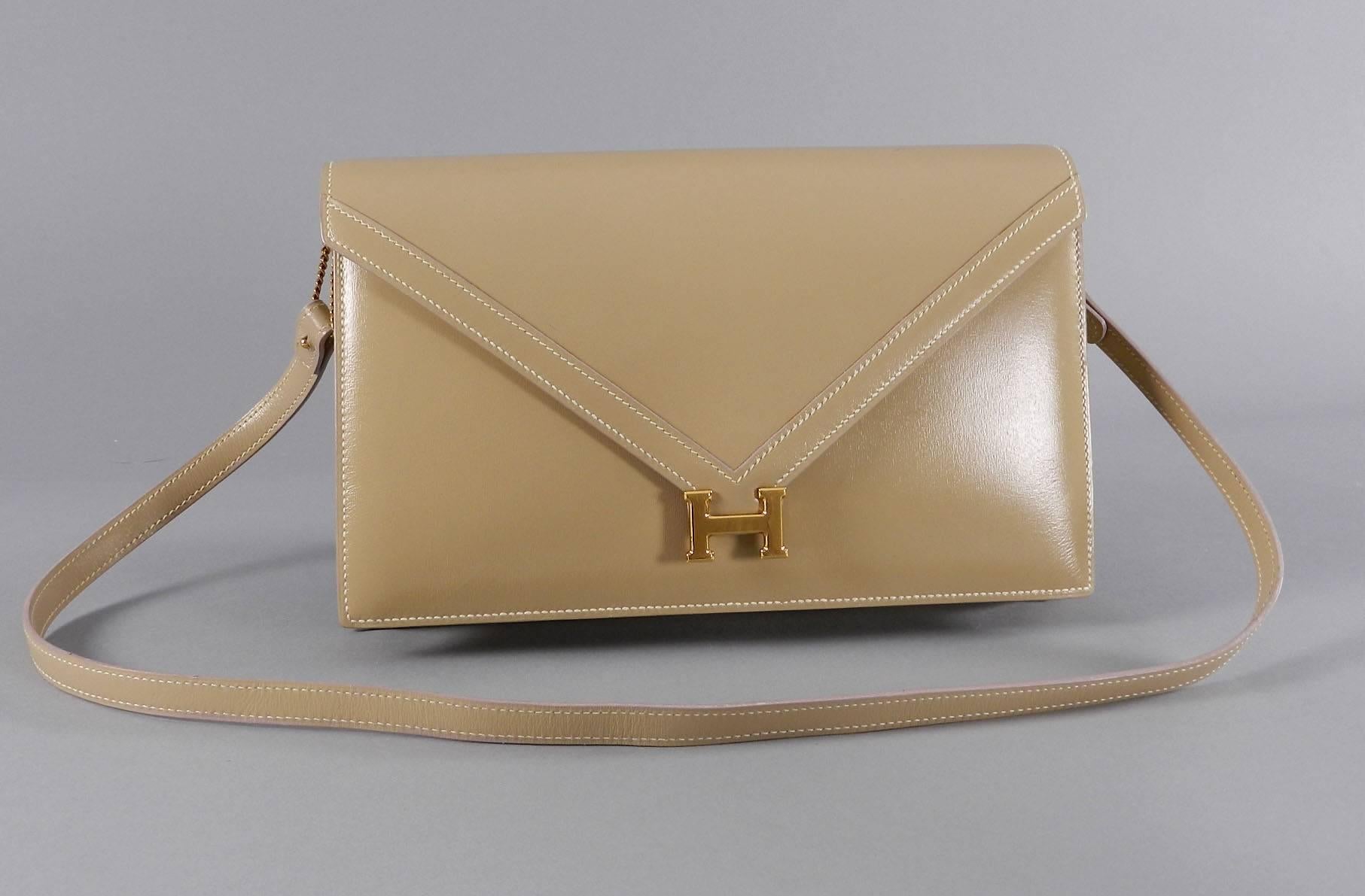 Vintage Hermes Lydie bag. Beige with soft ivory lambskin interior. Shoulder strap is removable when used as a clutch bag. Date stamp Q in circle for 1987. Body measures 10 x 6.5 x 1.75