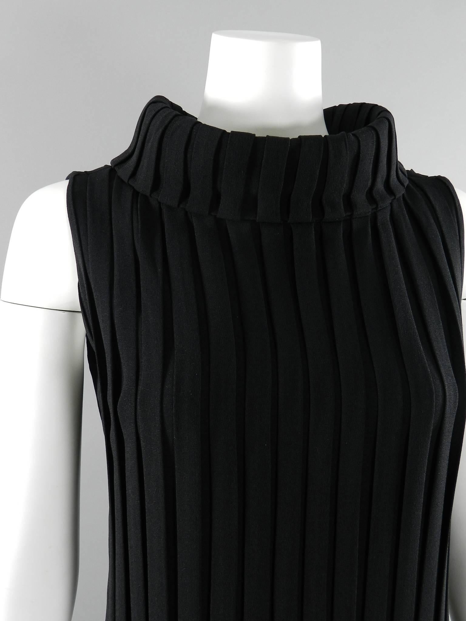 Vintage 1960's Mademoiselle Ricci by Nina Ricci black pleated column gown. Vertical pleats at front and back of dress that open up at bottom skirt hem. Sides of dress have a solid panel of un-pleated fabric. Center metal back zipper and fold-down