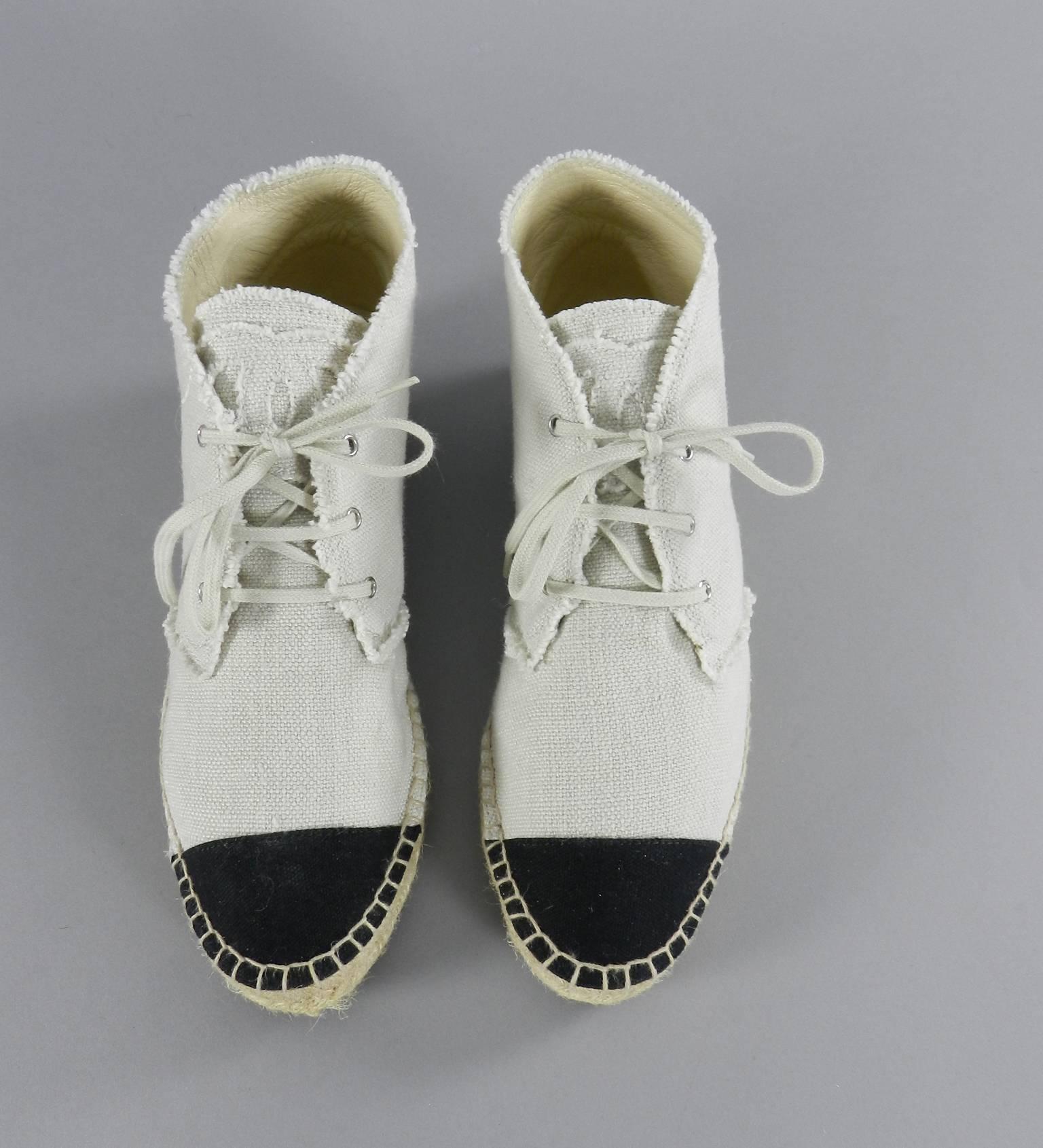 Chanel 2015 cruise / resort high top espadrille shoes. Unworn - no box.  Natural linen color with CC at tongue and black cap toe and heel.  Marked size 41. 

We ship worldwide. 