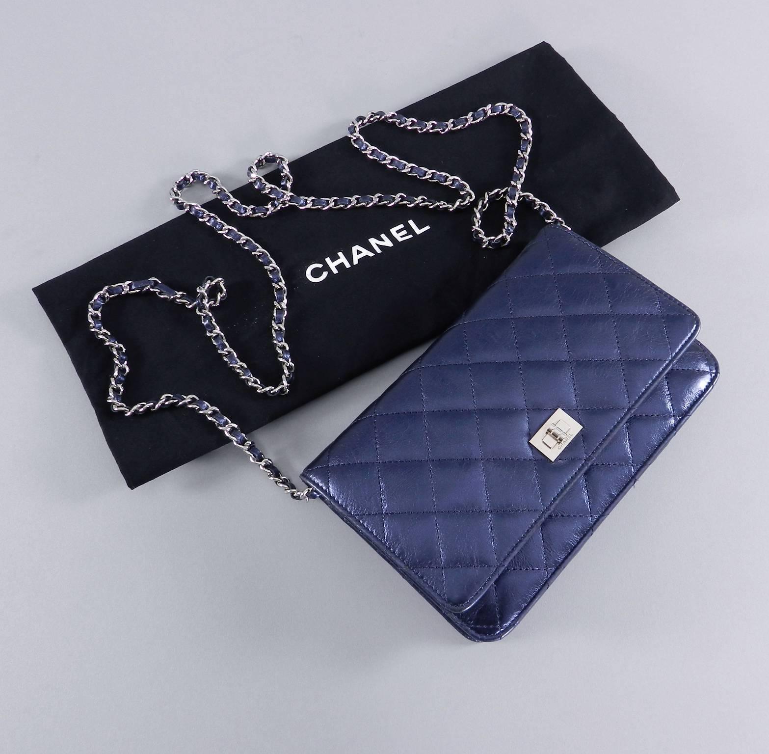 Chanel navy metallic quilted wallet on a chain with silver hardware. Excellent pre-owned condition. Has a Mademoiselle silver tone clasp and a slightly crackled textured leather (not smooth).  Serial number is 12-series for year 2008-9. Comes with