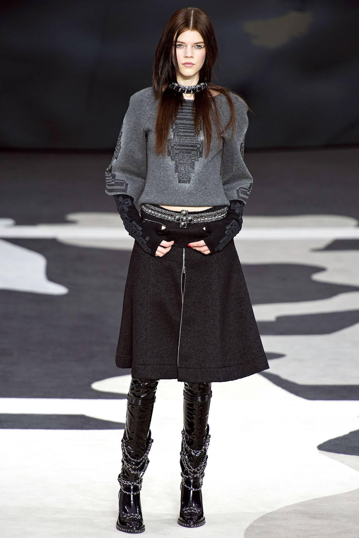 Chanel 2013 Fall runway black wool skirt.  Silver zipper details. Front zipper can be undone to reveal a shorter mini-skirt layer. 80% wool, 15 silk, 5 nylon. 100% silk lined. Garment is tagged size FR 36 (USA 4). To fit 25-26