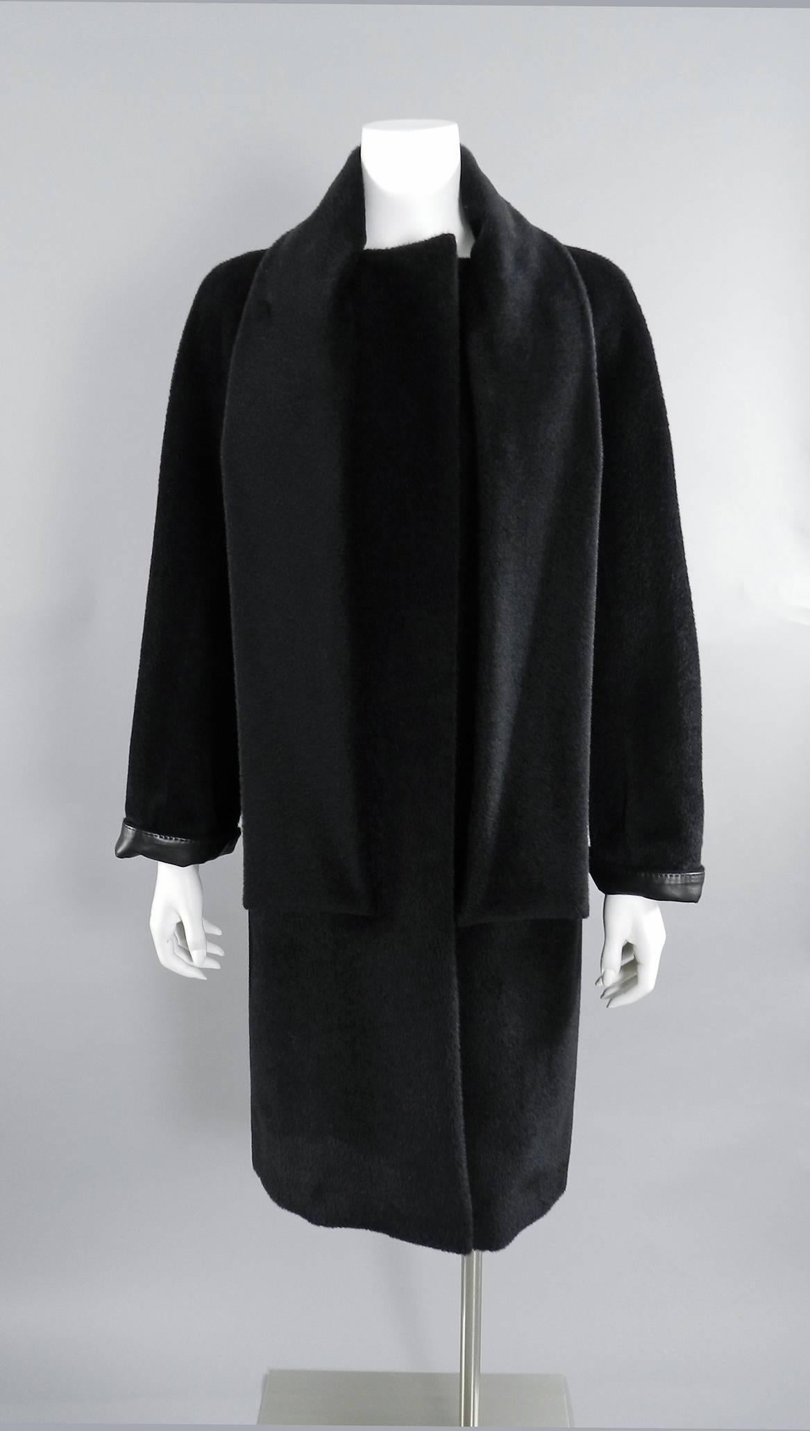 Hermes black alpaca and leather trim coat. Textured alpaca wool with leather facing on interior front, pockets, and cuffs.  Attached sashes at neck, straight loose-cut design, hidden side hip pockets.  Tagged size FR 38 (USA 6) but can also fit an