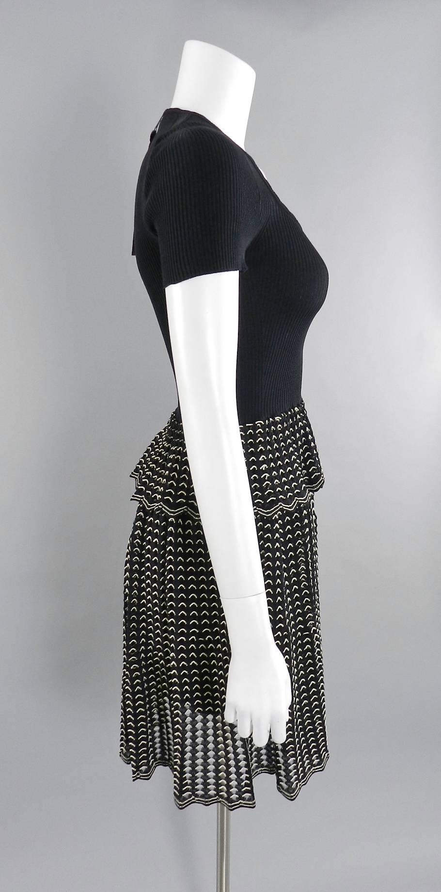 Alexander McQueen black ribbed stretch knit dress with black and white eyelet skirt.  New with tags.  Stretchy pullover design with no zippers or closures.  Tagged size M (approx. size USA 6/8). To fit 34-35" bust, 27-29" waist, semi full