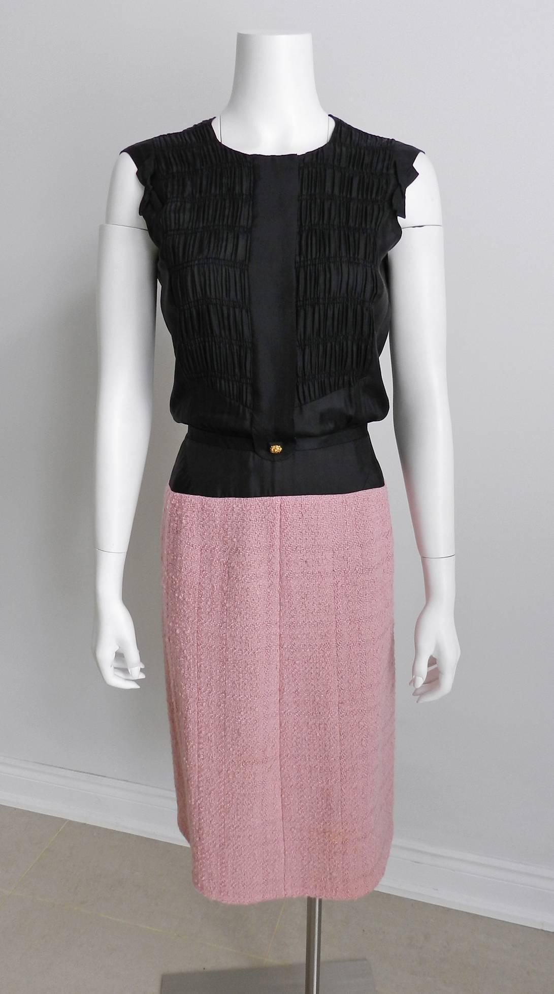 Chanel vintage Spring Summer 1963 Haute Couture pink and black dress and jacket suit.  Numbered under the main label. Pink boucle wool and black silk with gold metal lion head buttons.  The same design can be found in the collection at the