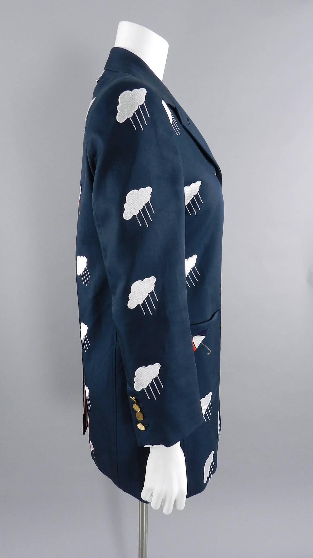 Thom Browne Navy Embroidered Coat with Umbrellas and Clouds.  Gold buttons at front and cuffs, striped interior lining, signature red, white, blue striped ribbon trim. $3780+ original retail price tag in pocket. Tagged size IT 42 (USA 6). Garment