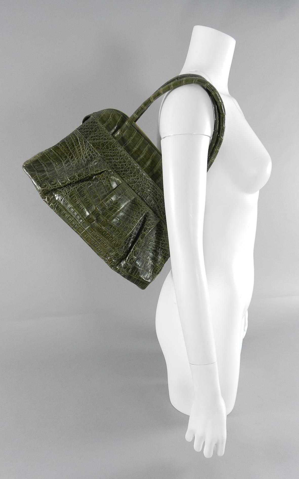 Nancy Gonzalez Dark Green Crocodile Bag.  Double top handle design with goldtone metal zipper.  Interior is lined with green suede. Includes duster. Excellent clean pre-owned condition.  Measures 13.5 x 9 x 5" with a 5.5" drop handle. 

We